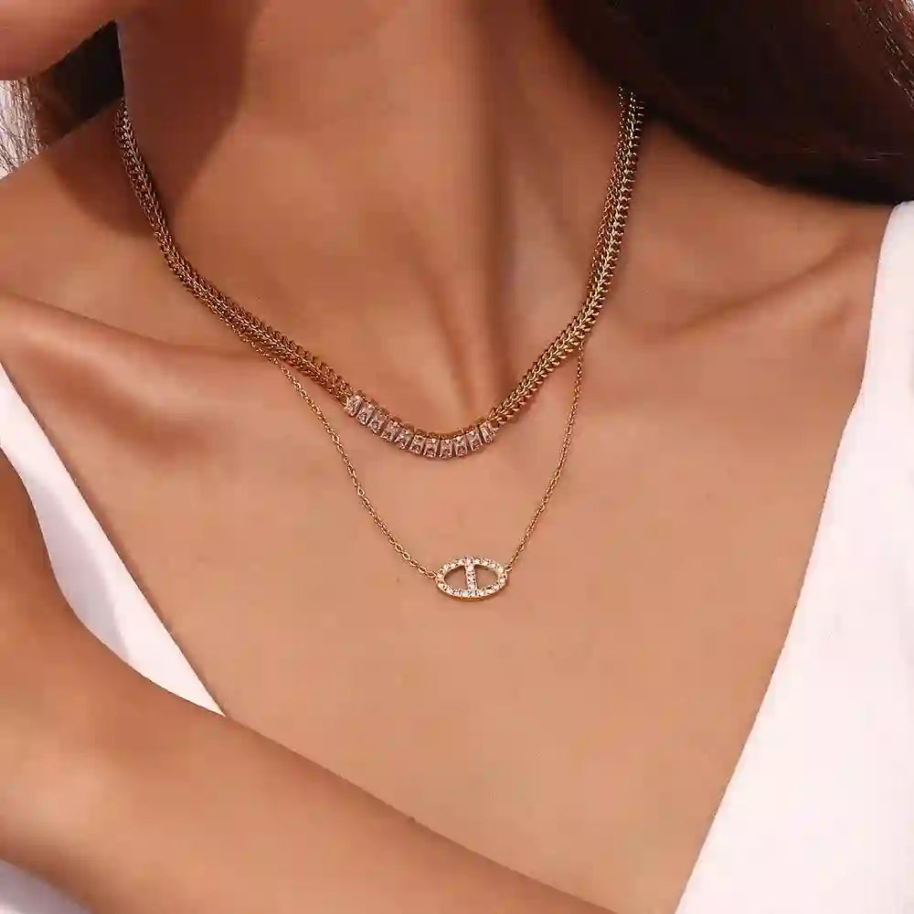 woman wearing 18k Gold Plated layered necklaces with sparkling oval and link designs on bare skin