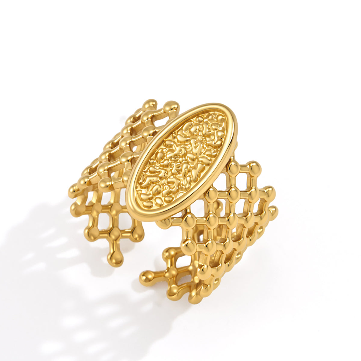 Gold ring with intricate design on a white background