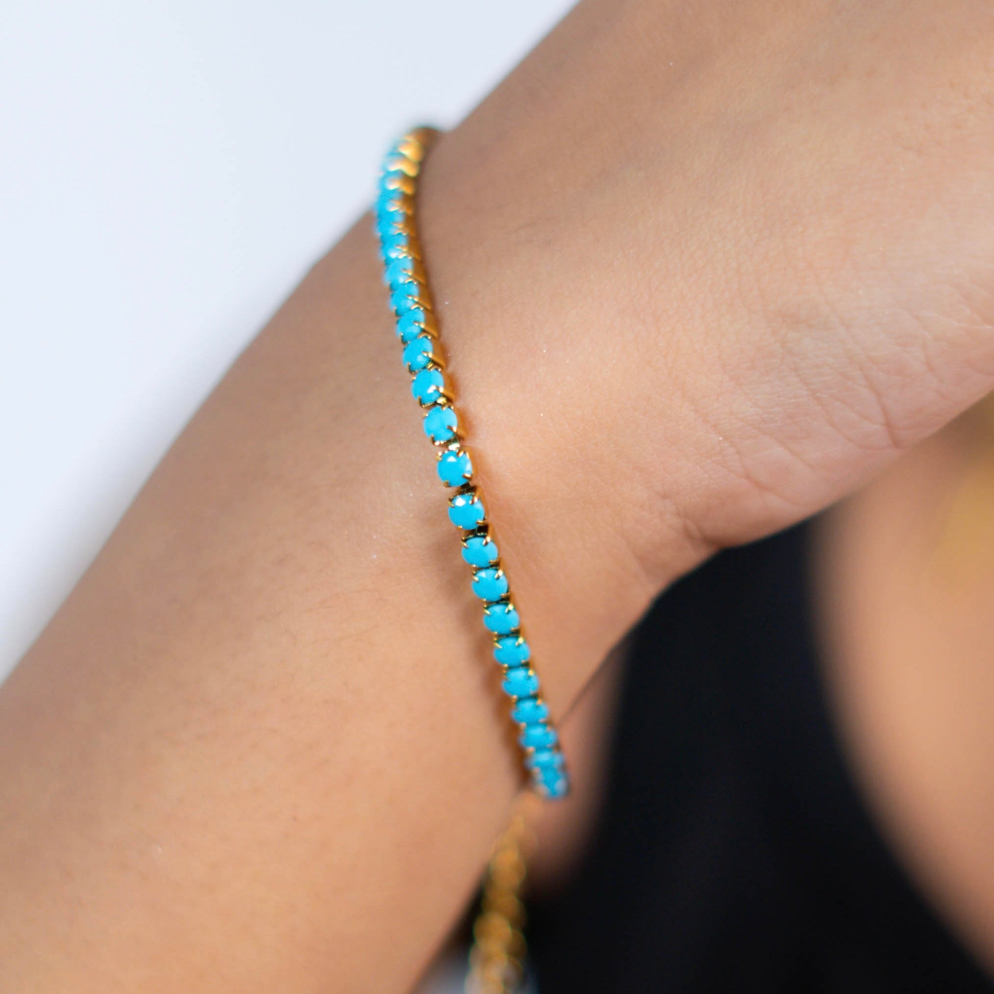 Turquoise beaded bracelet on a wrist against a white background