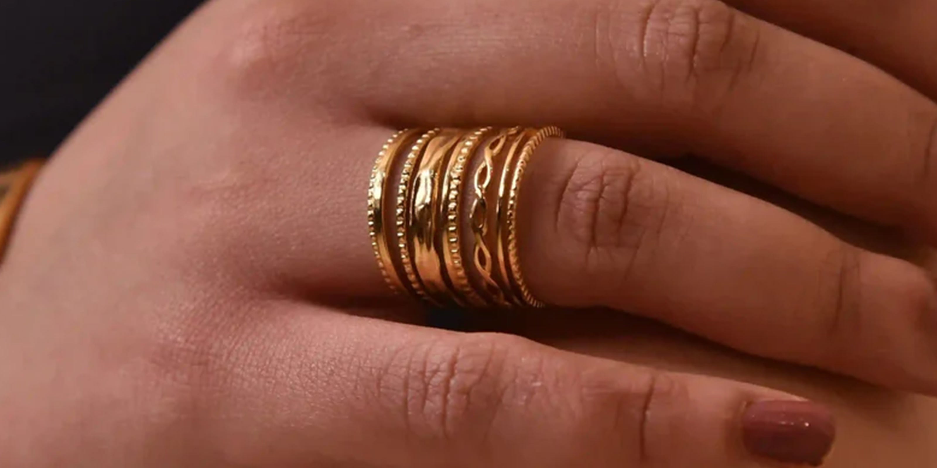 Adjustable Rings Collection Featuring a Close-up of a girl's hand wearing a gold plated open-ring with intricate design.