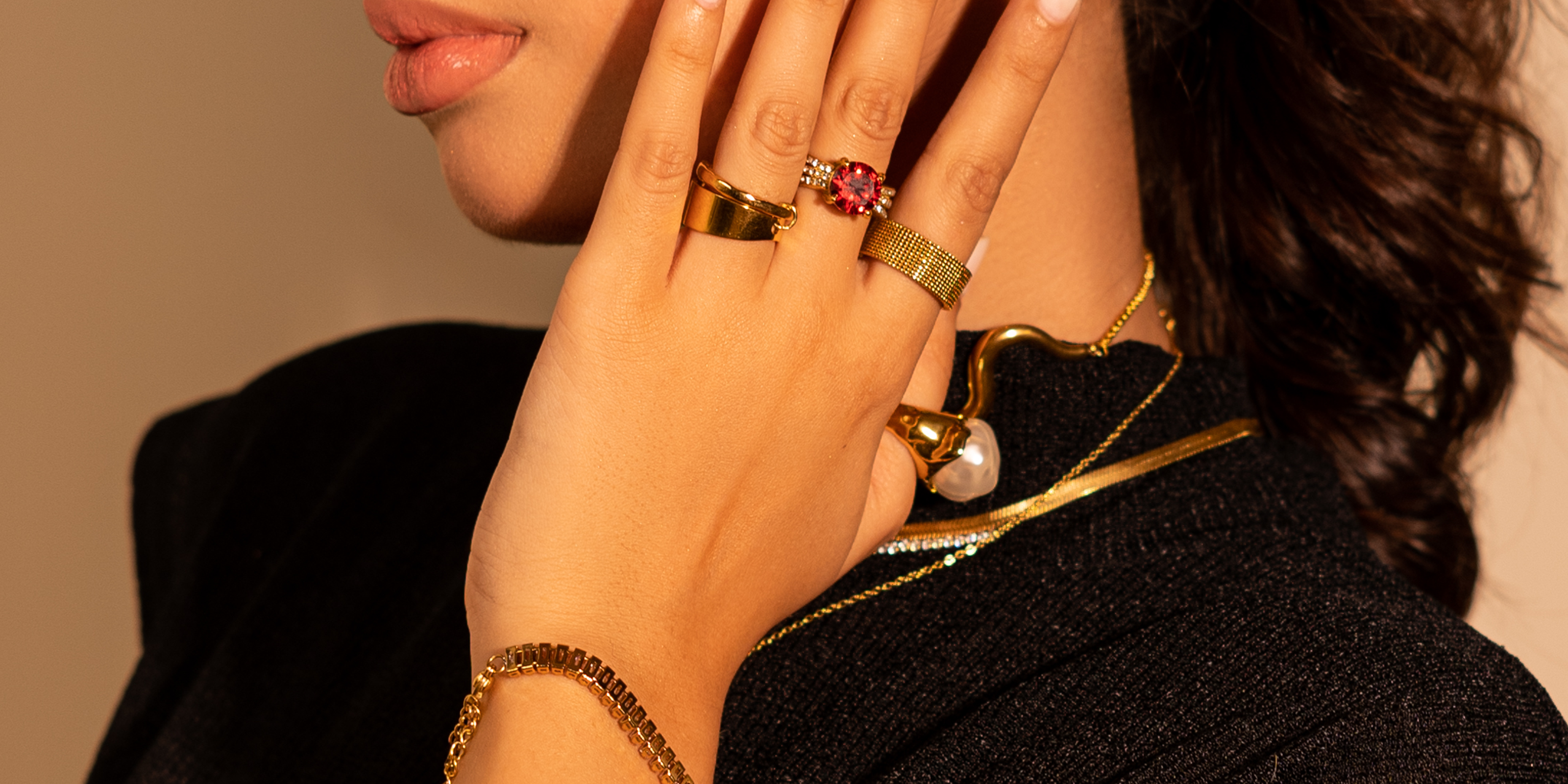 Female posing with her hand on the left side of her face, left profile view, wearing party ready jewelry for events and special occasions.
