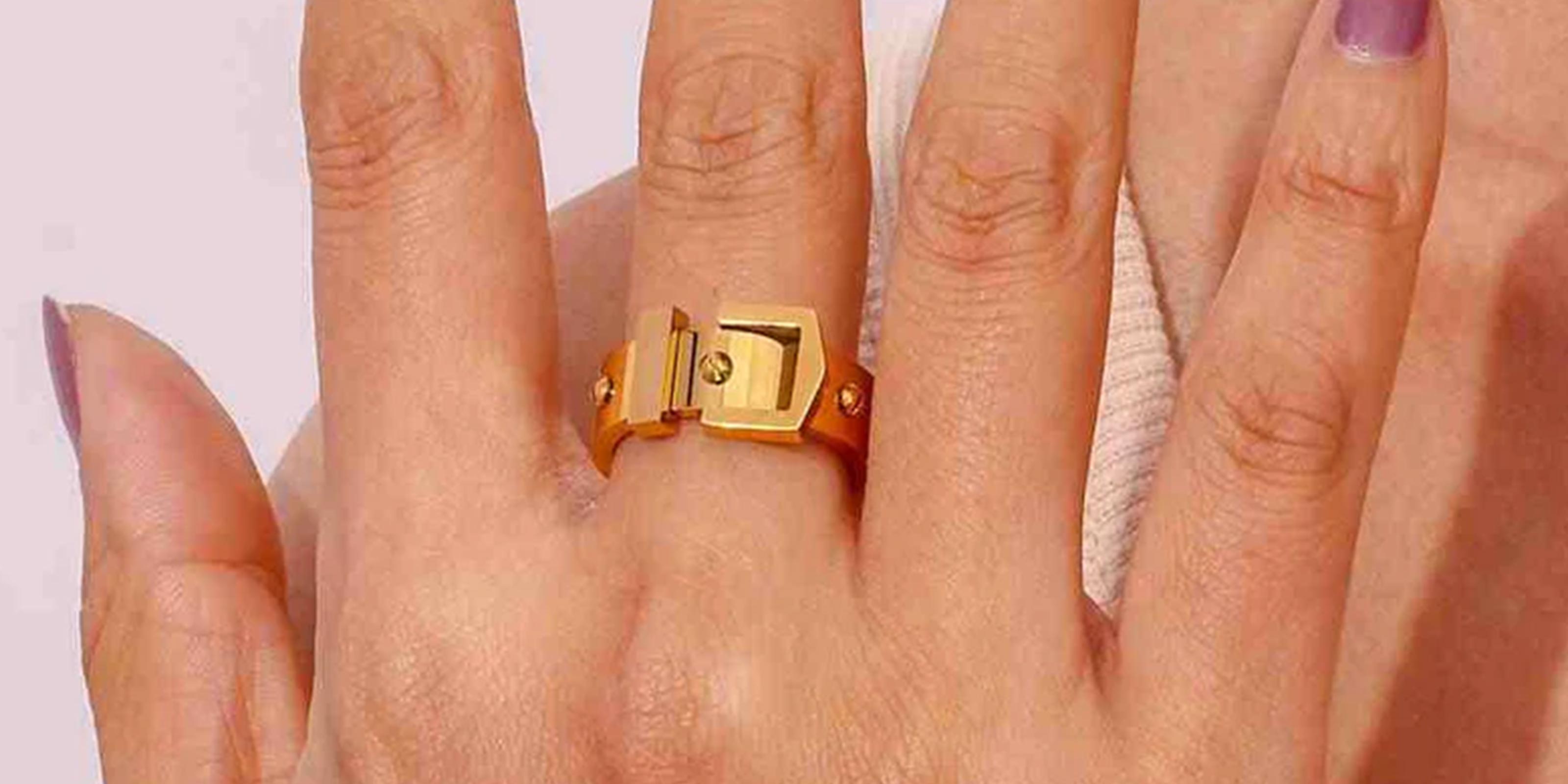 Solid Gold ring Collection Showcasing Girl Wraring a Buckle ring with a lock design on a finger against a neutral background