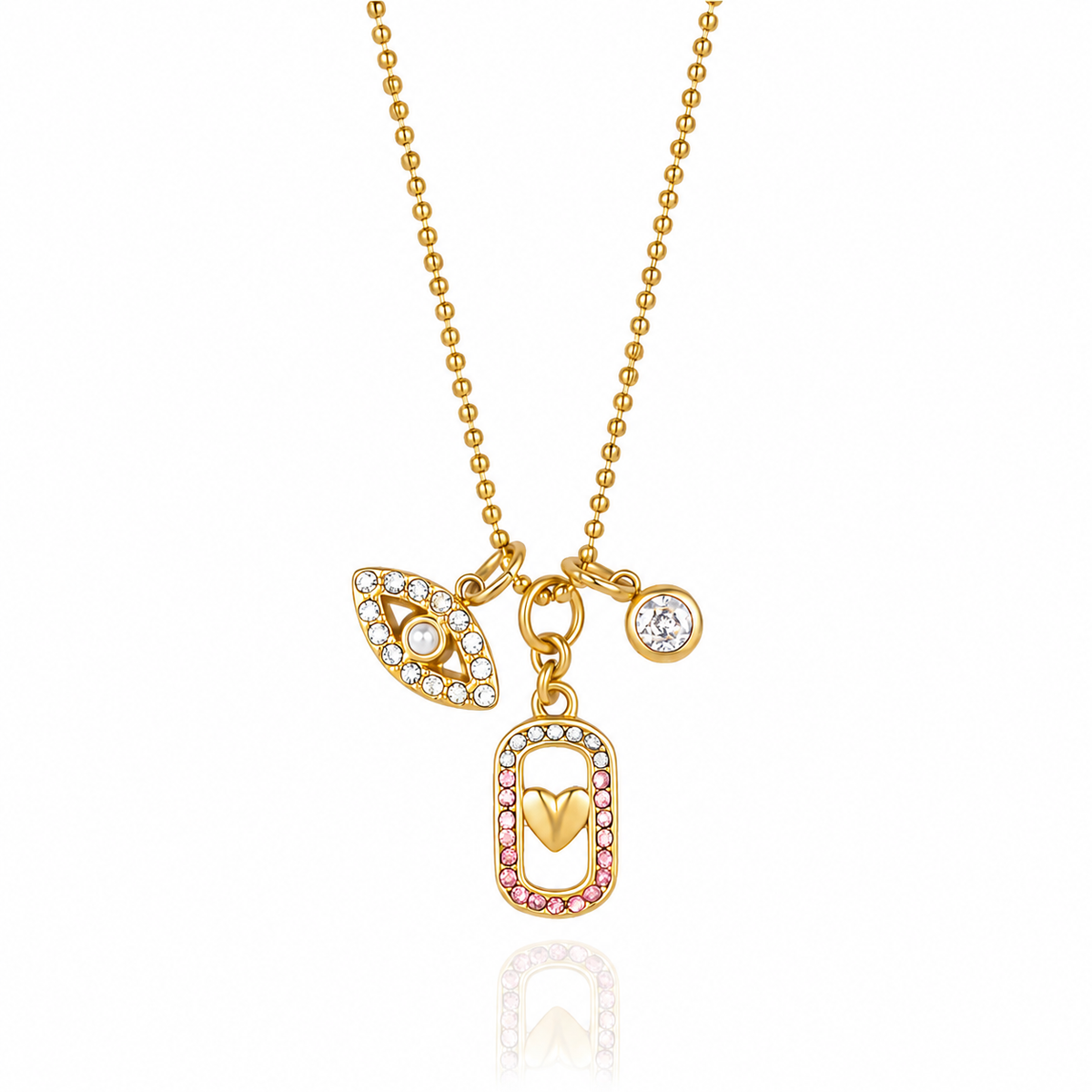 Gold ball chain necklace with a multi-charm pendant featuring an evil eye, a rectangular frame with pink and clear stones, and a small round clear stone charm, shown on a white background with a soft reflection.