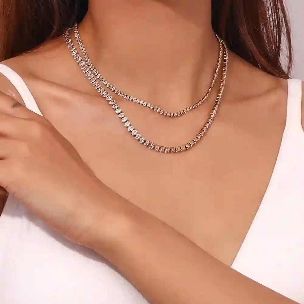 woman wearing 18k Gold Plated tennis chain necklaces Diamond cut neckchain and linea necklace with white top, close-up on neck and collarbone