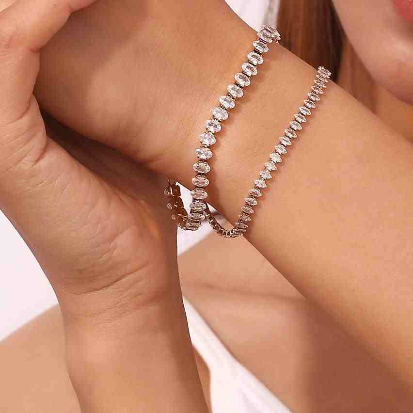 closeup of a girl's hand wearing linea tennis bracelet with diamond cut zircons.