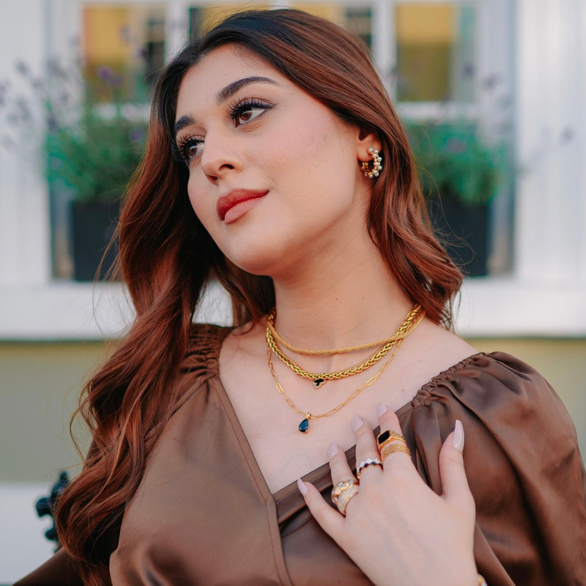 Model wearing Harper twisted-rope jean pendant, Midnight Clover, and Greek woven necklaces stacked together with Black clover, White clover bands, Malachite Black mesh rings, Nysera ring, and studded Domsley ring.