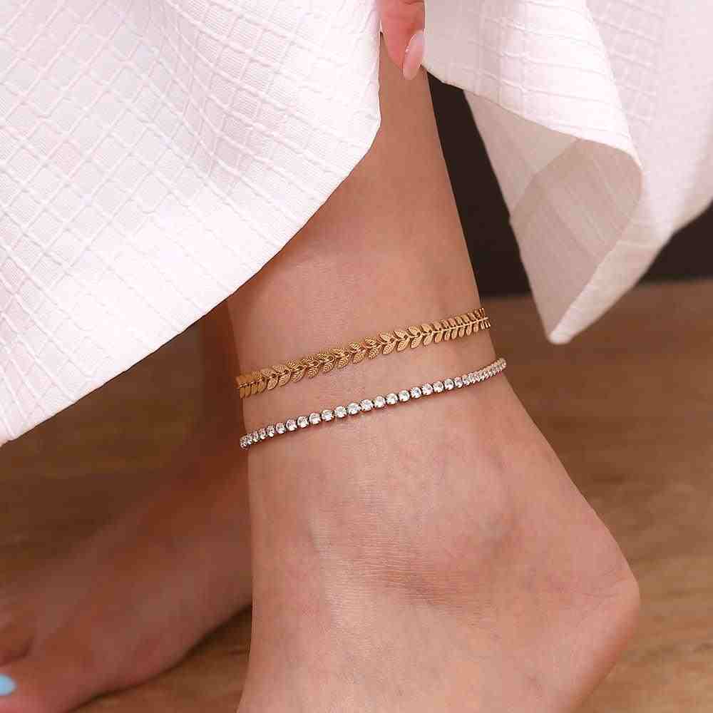 Wearing a gold plated leaf shaped chain anklet with another anklet beaded design.