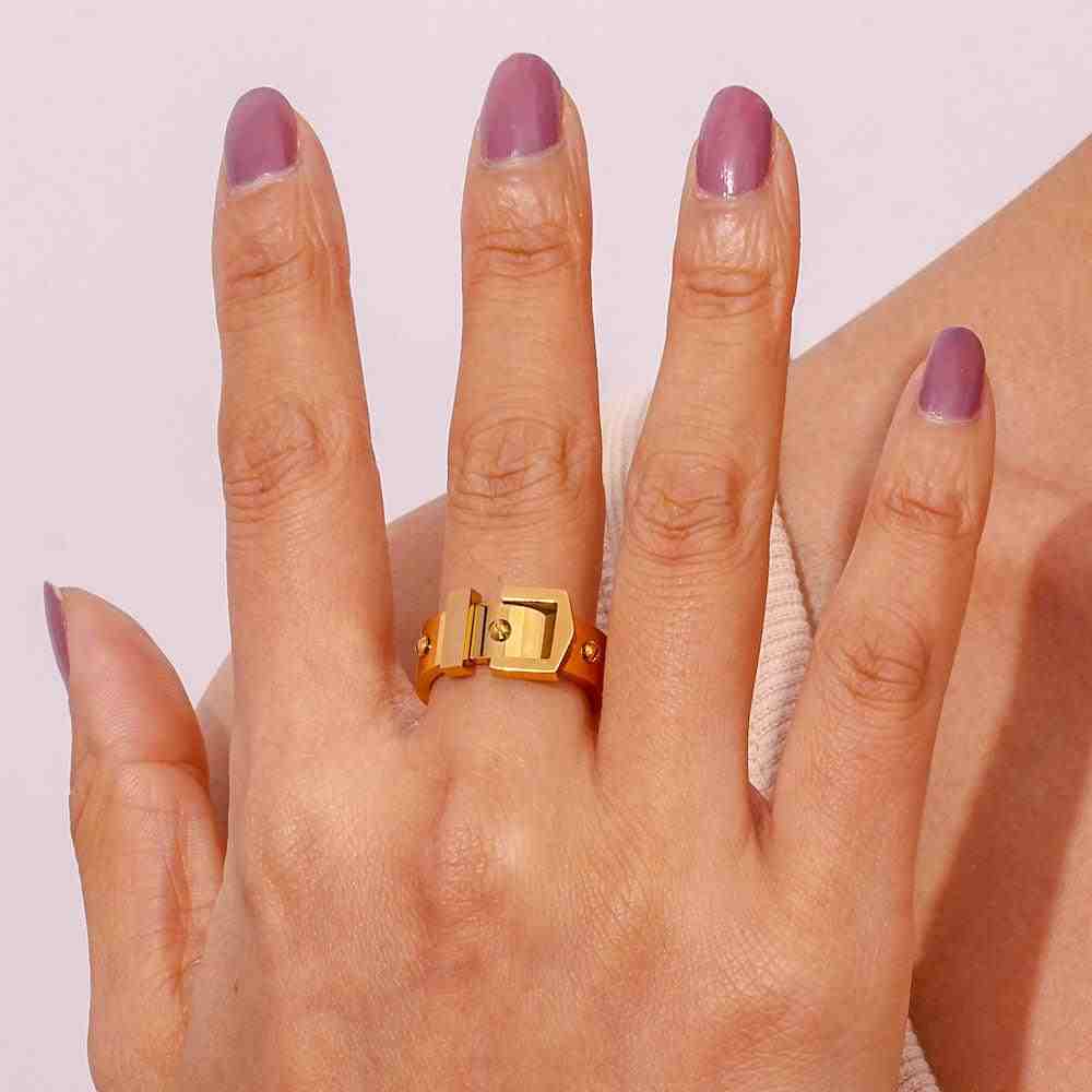 Closeup of hand wearing Buckle up Ring in Middle Finger with indigo nailpaint on all fingernails.