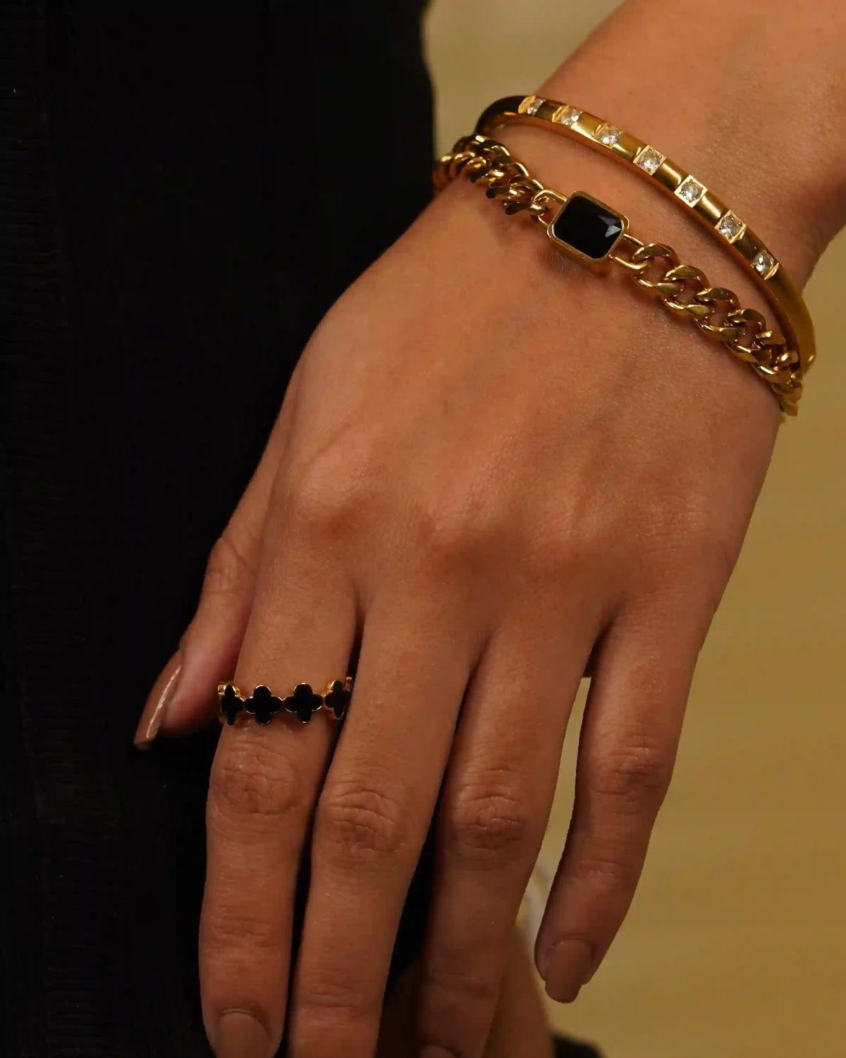 Girl wearing Gold plated Clover Black Band with claro cuff and another Cuff bangle.