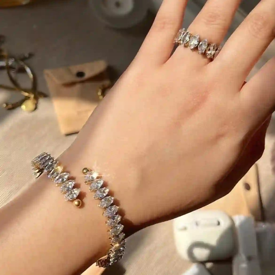 Closeup of a girl's hand wearing fifi ring with victoria cuff bangle. 18k Gold Plated Adjustable open cut design with Marquise set zircons.