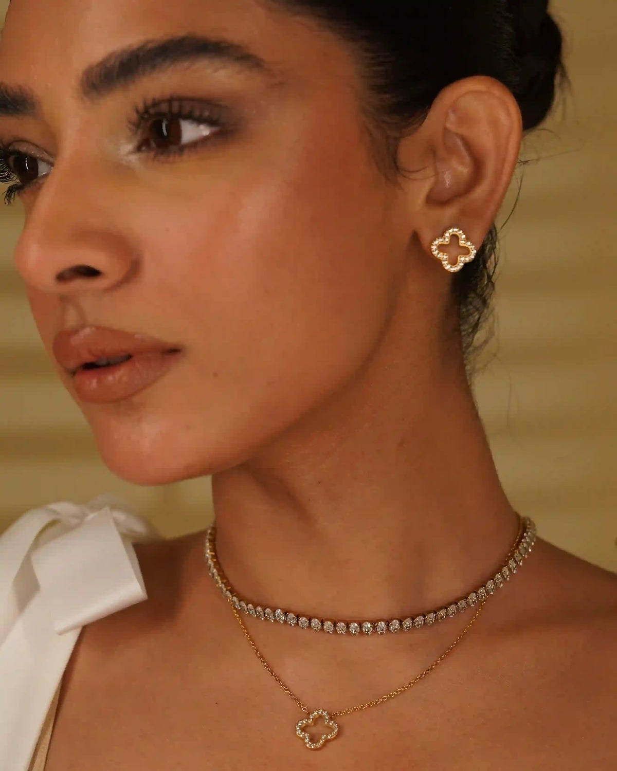 Side View of Woman Wearing Hollwo CLover Studded Studs and Hollow Clover Studded necklace with Linea Necklace.
