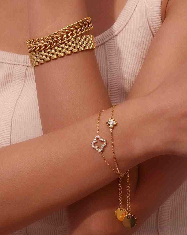 closeup of both hands stacking Michael bold bracelet and hollow clover studded bracelet. Open-Silhouette Quatrefoil Design Pave Zircon Layering handchain.