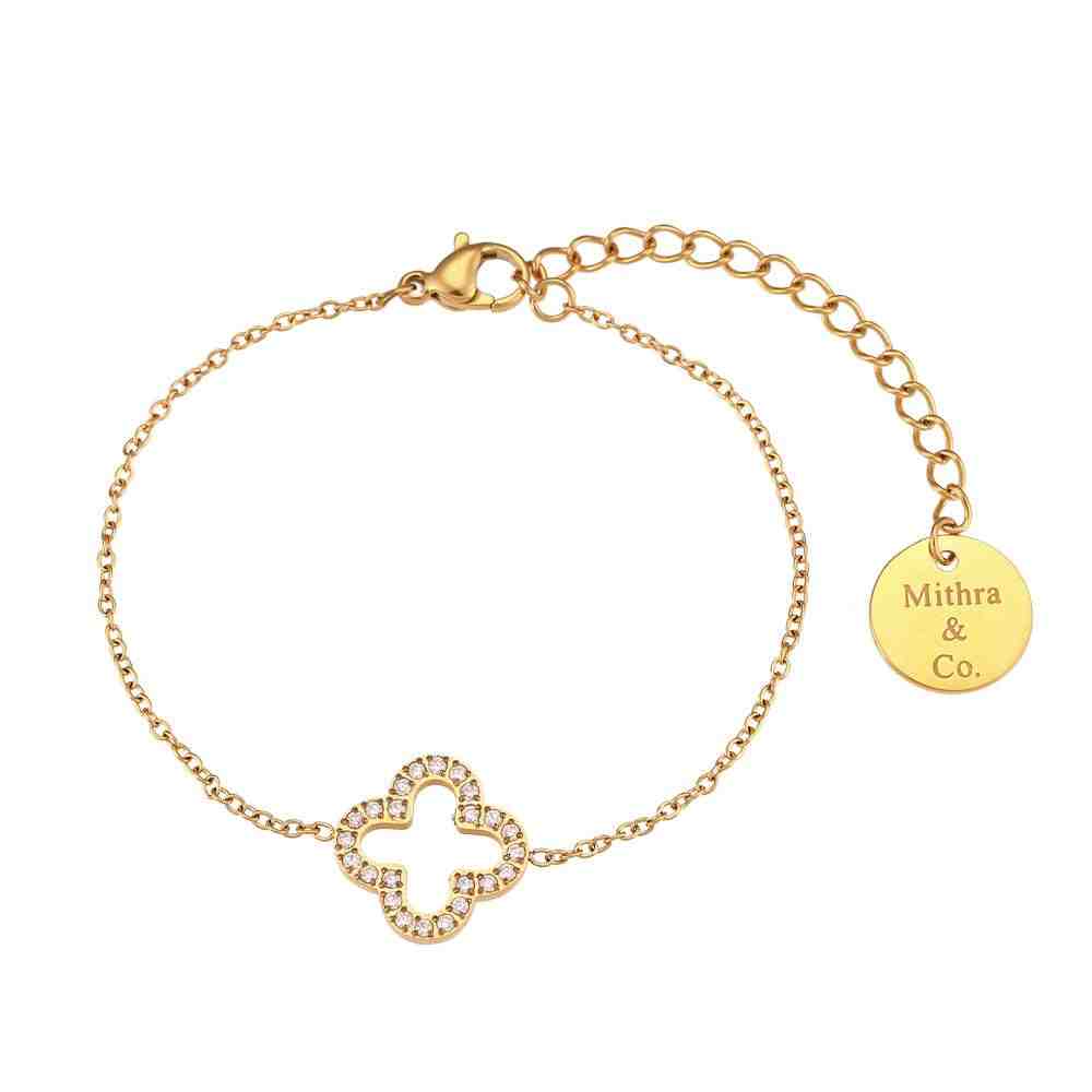 Studio shot of Gold plated hollow clover studded bracelet. An Open-Silhouette Quatrefoil Wrist Chain with Pave Zircon layering on a white bg.
