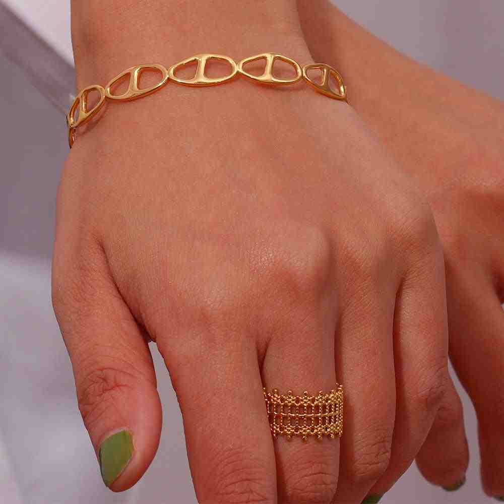 Closeup of a hand wearing 18k Gold plated mashion ring having a Beaded Grid Open-Work Lattice Architecture.