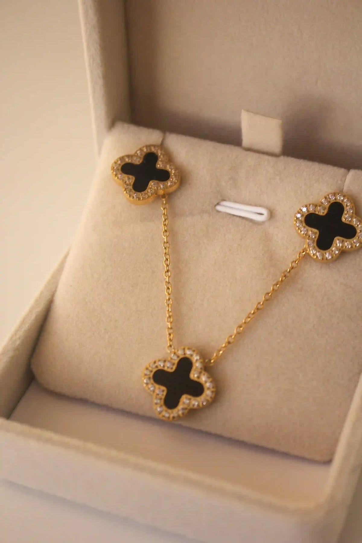 18k Gold plated Clover Necklace Set of 3 Clover Motifs with Zircons studded around a black onyx inlaid stone in center. Shop Now.