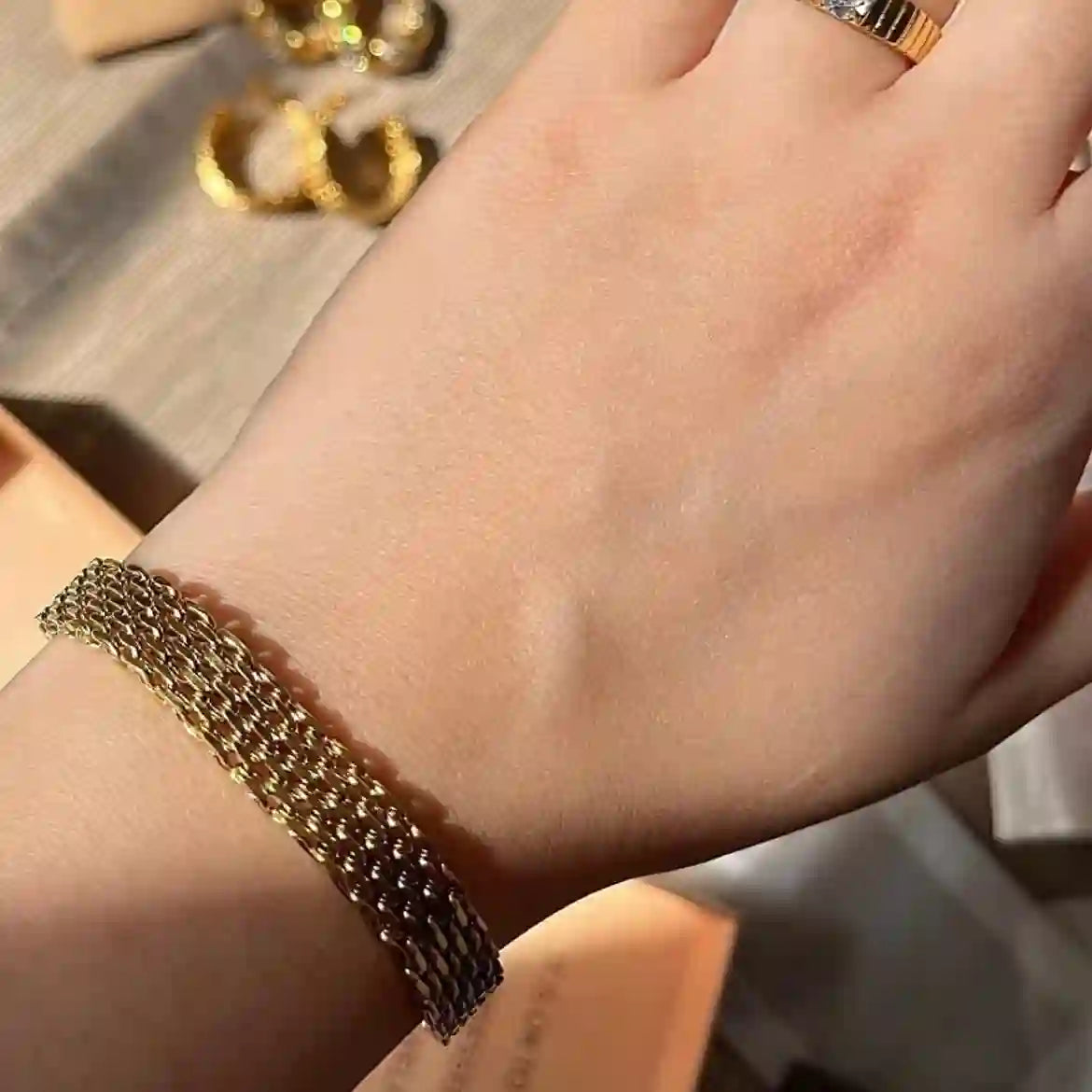 Close-up of gold plated mesh chain bracelet: Extreme close-up detail of Rowena bracelet, focusing on the intricate mesh links.