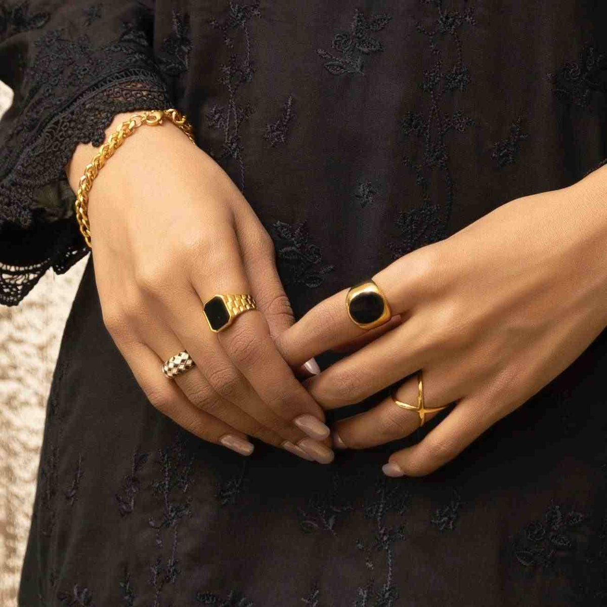 closeup of both hands wearing black onyx rings in index fingers