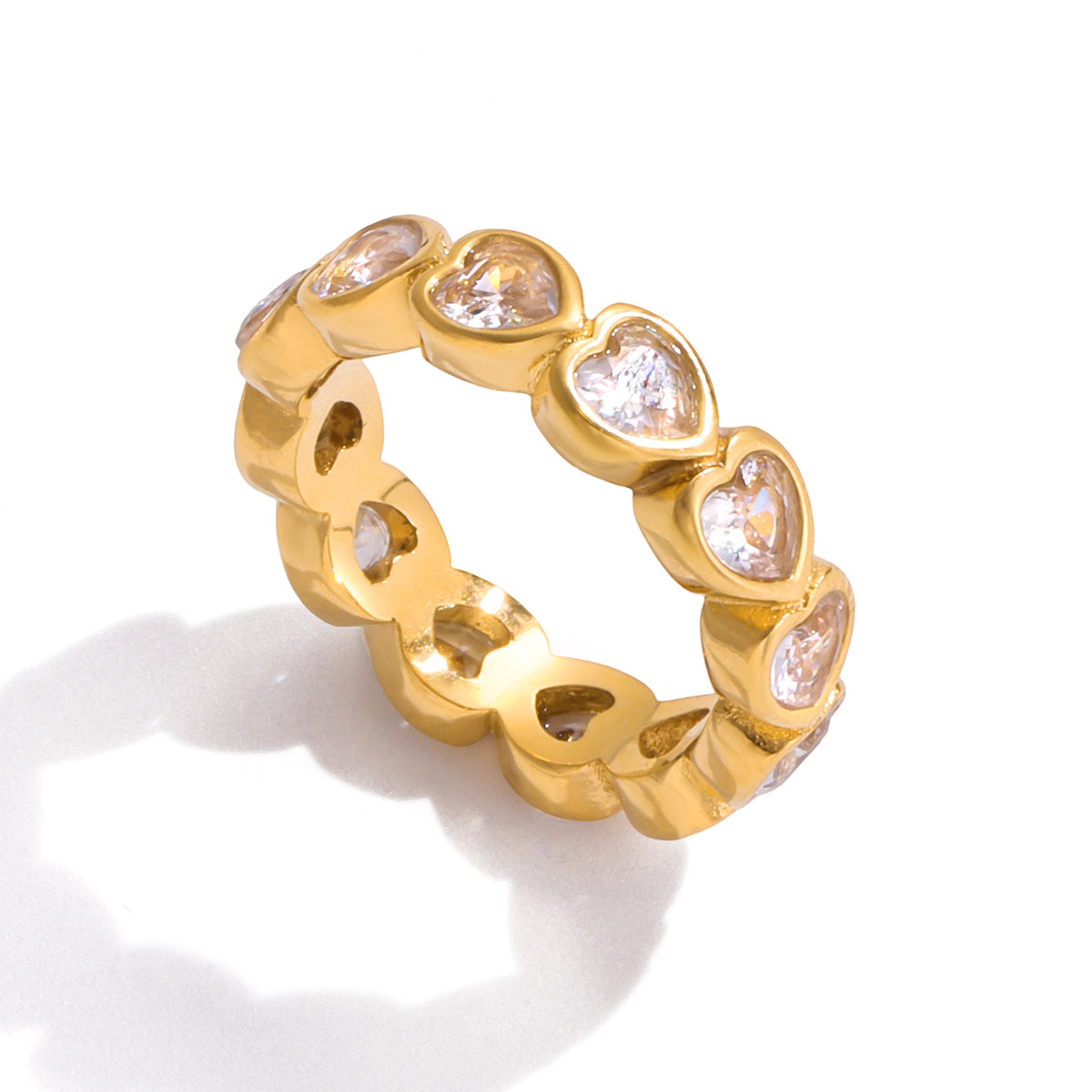 Gold finish ring with heart-shaped gemstones on a white background