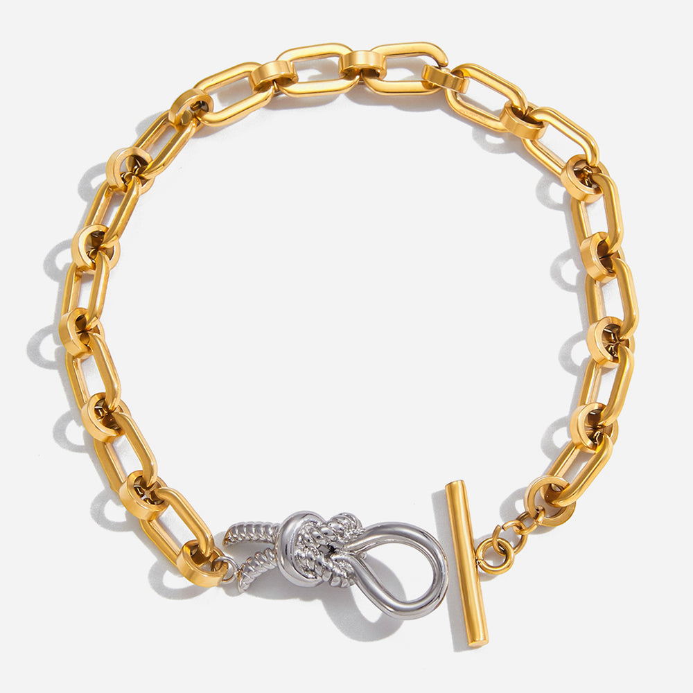 Norma T bracelet with a silver clasp on gold plated chain with a white background