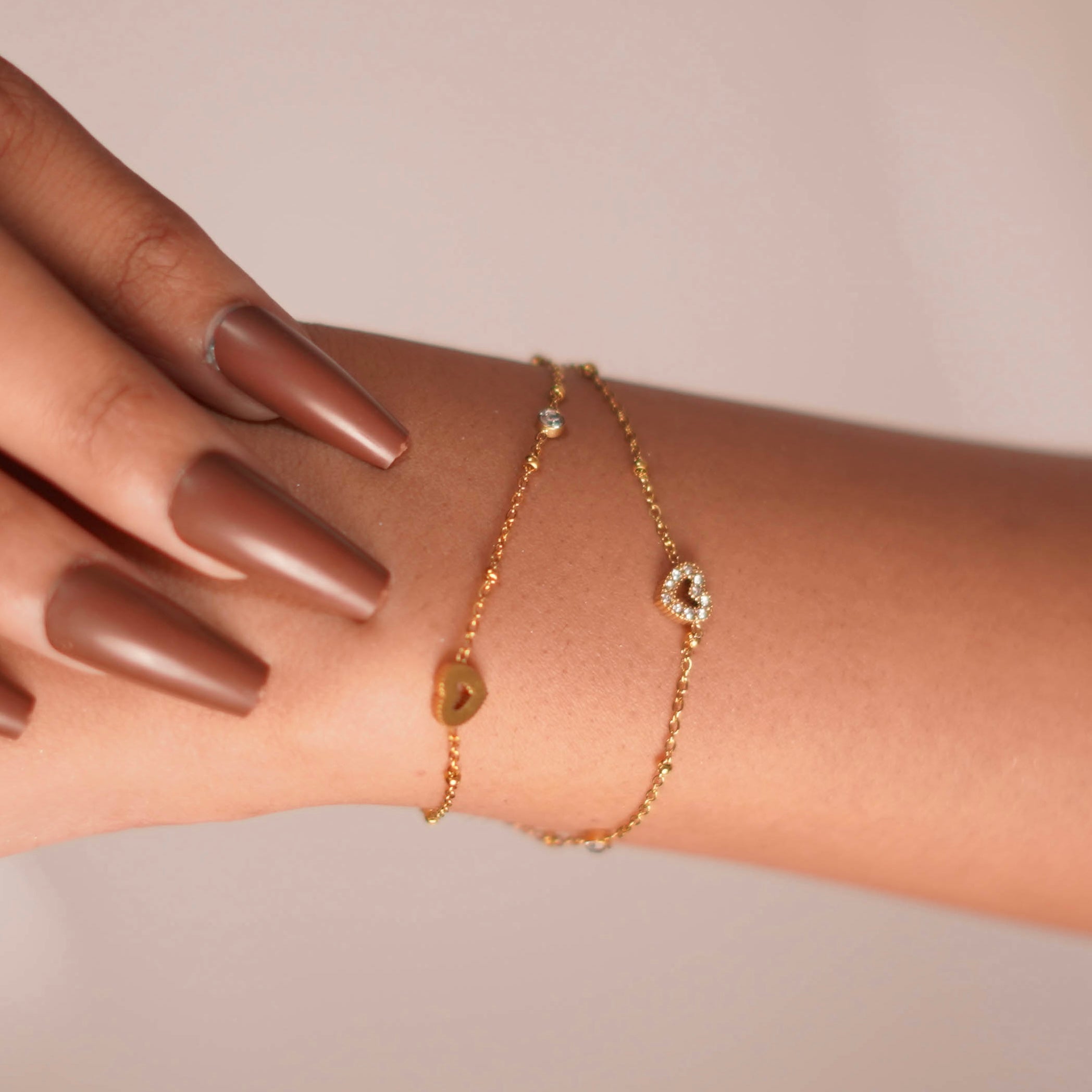 Gold bracelet on a wrist with a neutral background