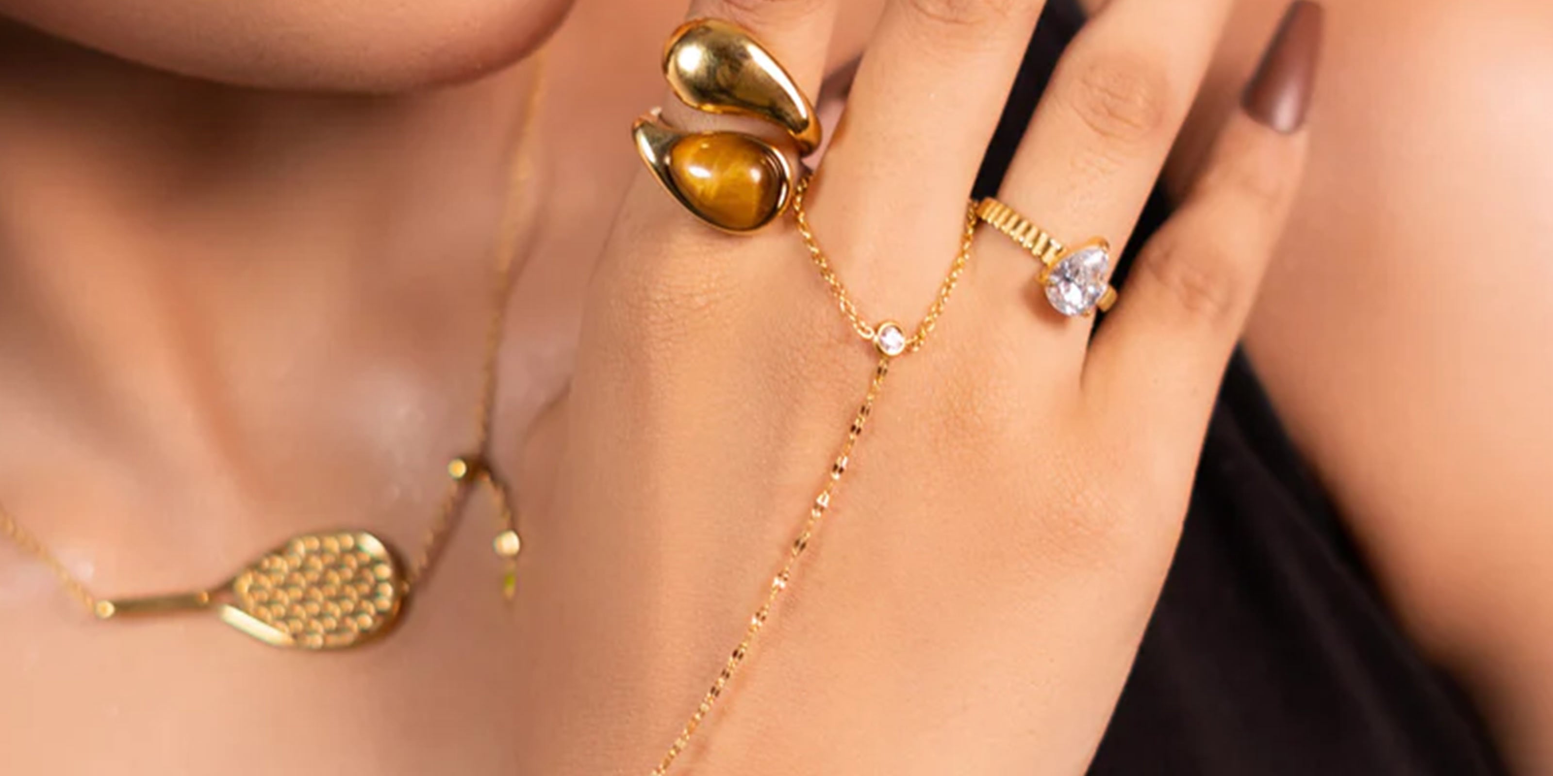 9-5 Vibes Collection Showcasig Close-up of a girl's hand wearing artificial gold jewelry (earring, necklace, and ring.)