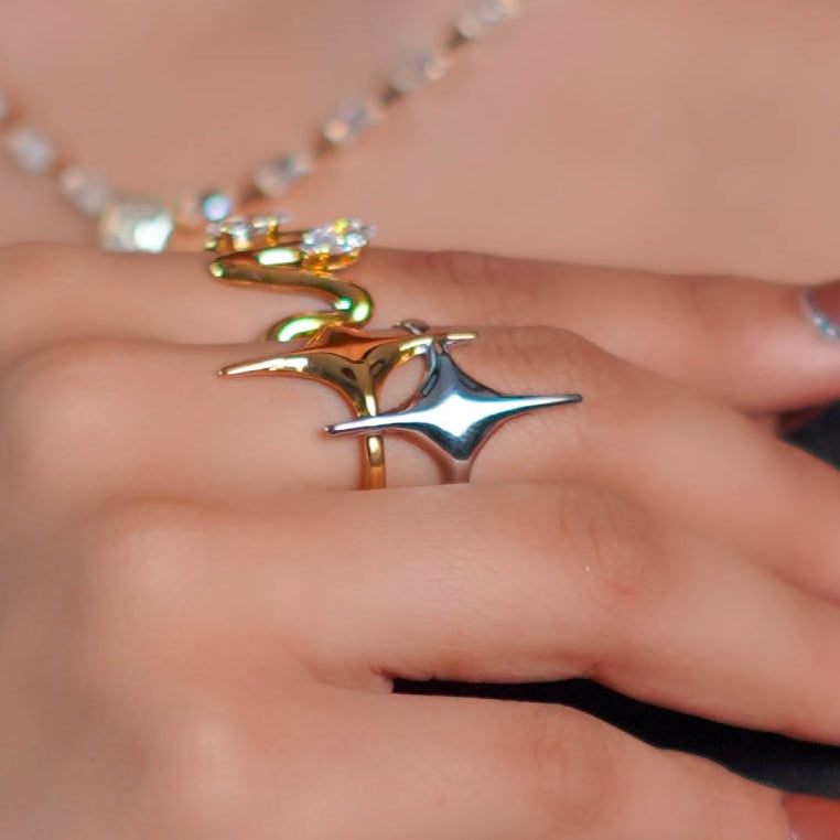 Close-up of a hand wearing a gold ring with a silver pendant.