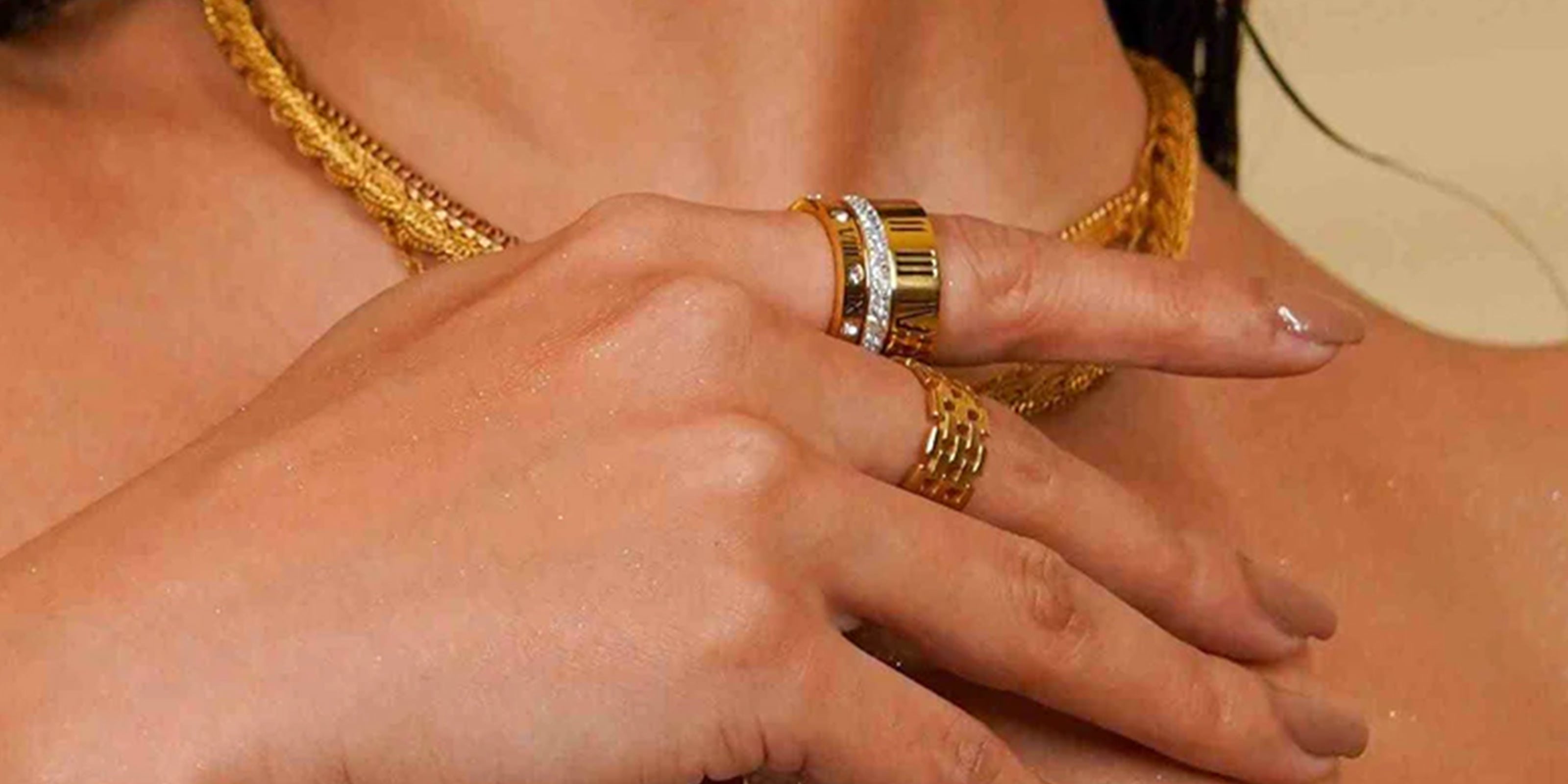 Band Rings Collection Showcasing a Close-up of girl's hands wearing gold Plated Band Rings on a neutral background