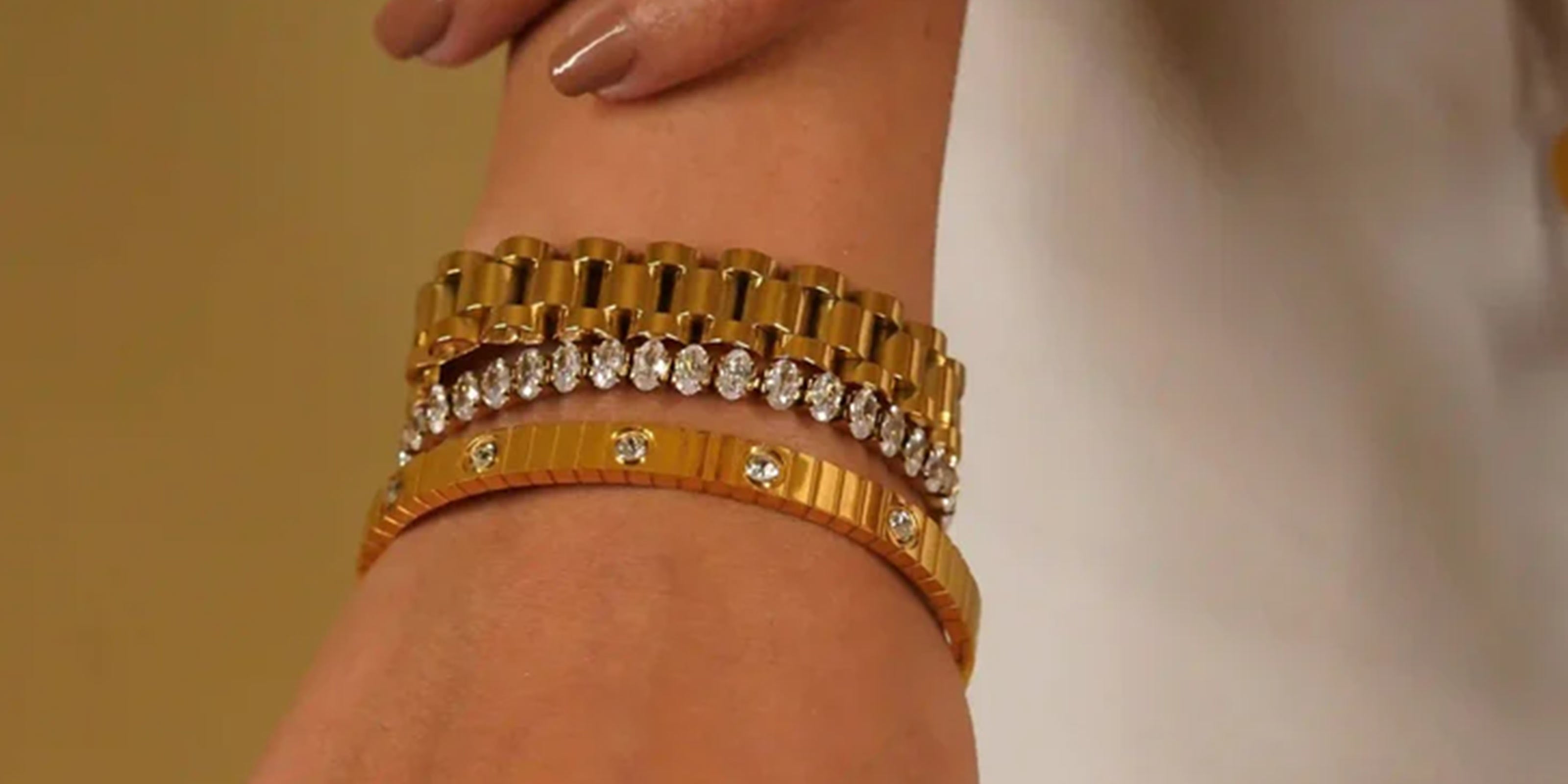 VIntage Collection Featuring Gold Watchband and Bracelets with embedded CZ stones on a girl's wrist against a neutral background