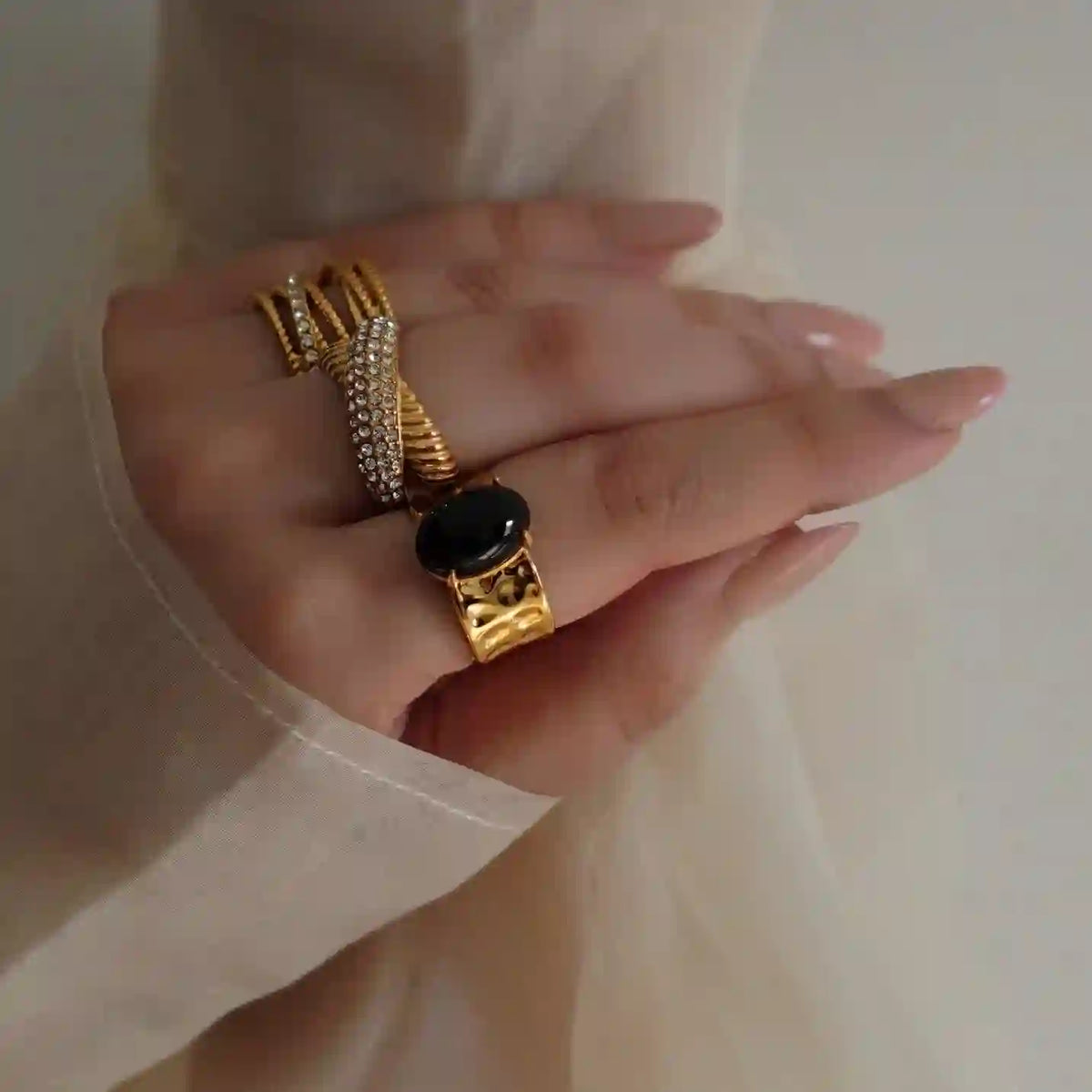 Girl wearing Crossover Ring with Briar Ring and Circa Ring having a hammered cuff and oval onyx station band design.
