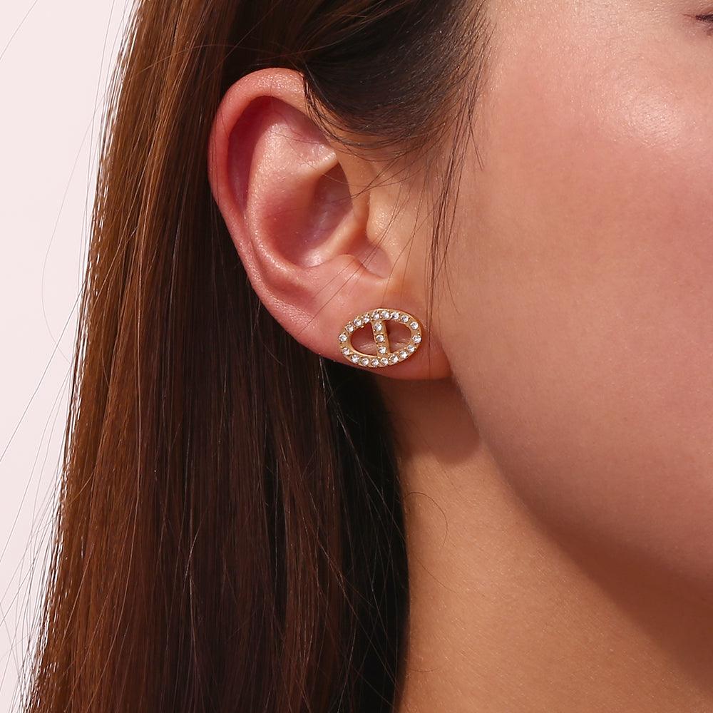 Closeup of a Girl's right ear wearing Dreams Studs - Shop 18k Gold Plated Pavé-Bordered Oval Link Earrings at Mithra and Co.