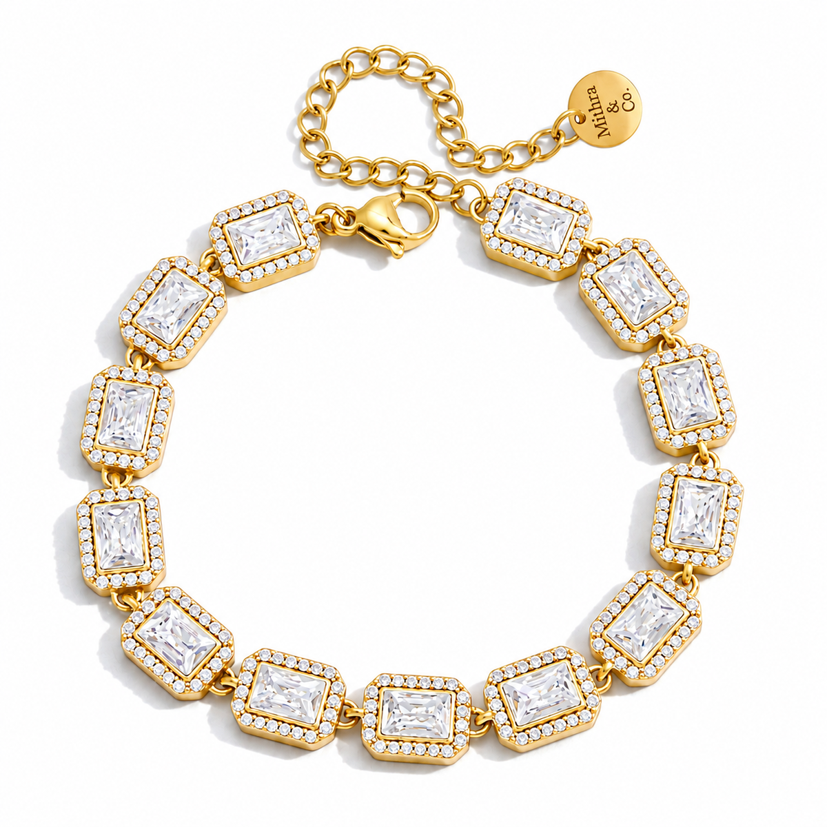 A gold link bracelet with rectangular clear gemstones in halo settings, displayed on a clean white background. The brand name 'MADLYN & CO' is engraved on the small gold tag attached to the chain.