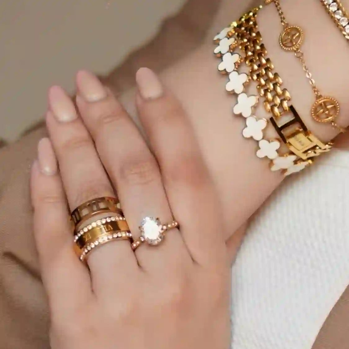 Girl wearing Mithra and Co bracelets and rings including carved roman numerals calligraphy ring.