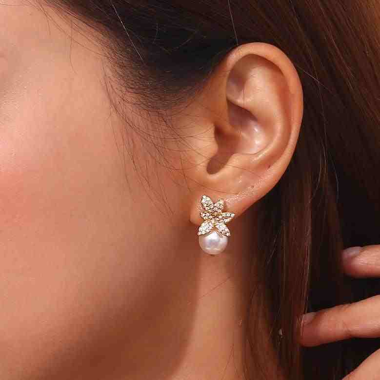 Girl wearing 18k Gold Plated Pave Crystal Flower Pearl Drop Earrings - Pirouette studs. Shop Now at Mithra and Co.