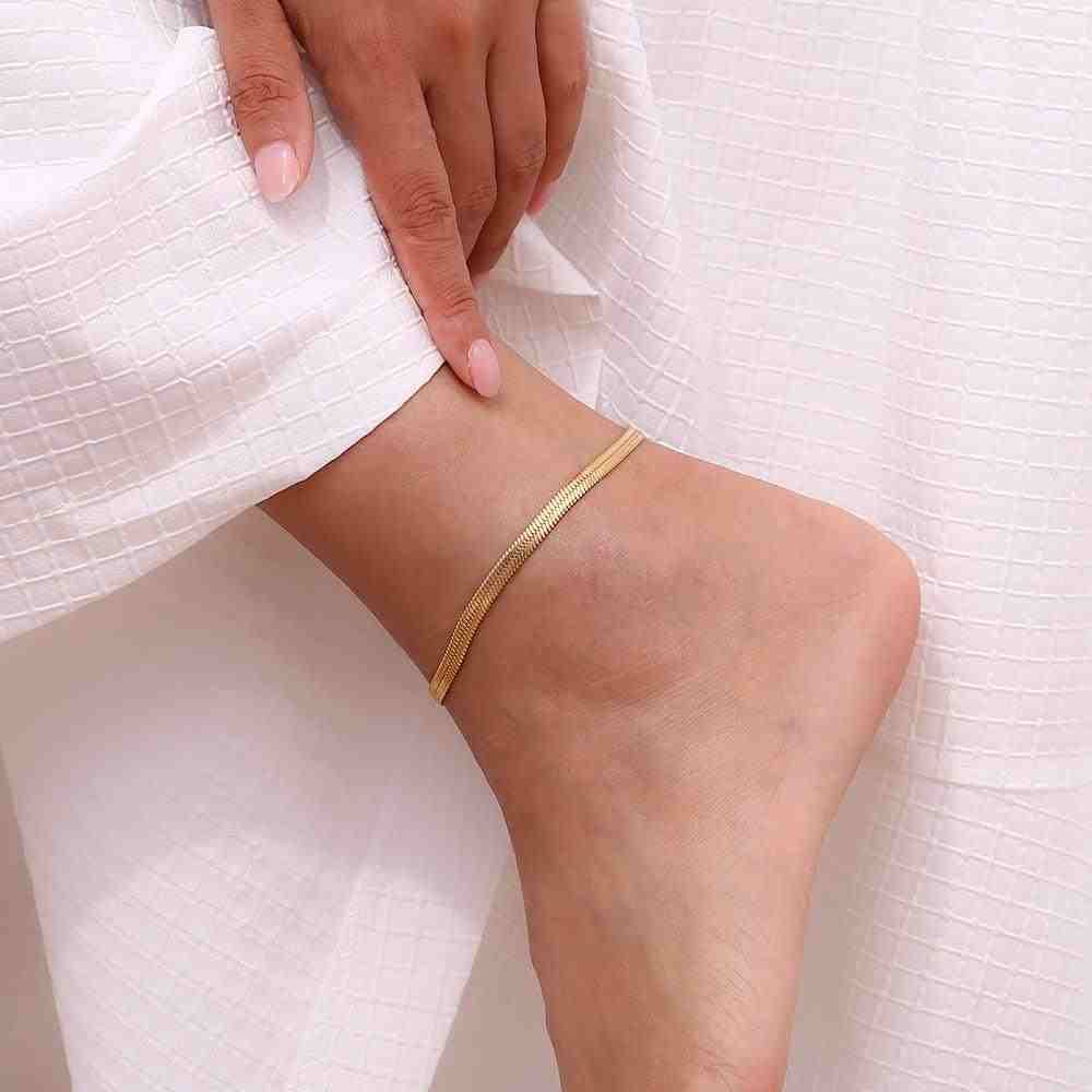 Woman wearing 18k Gold Plated snake chain anklet with white textured fabric