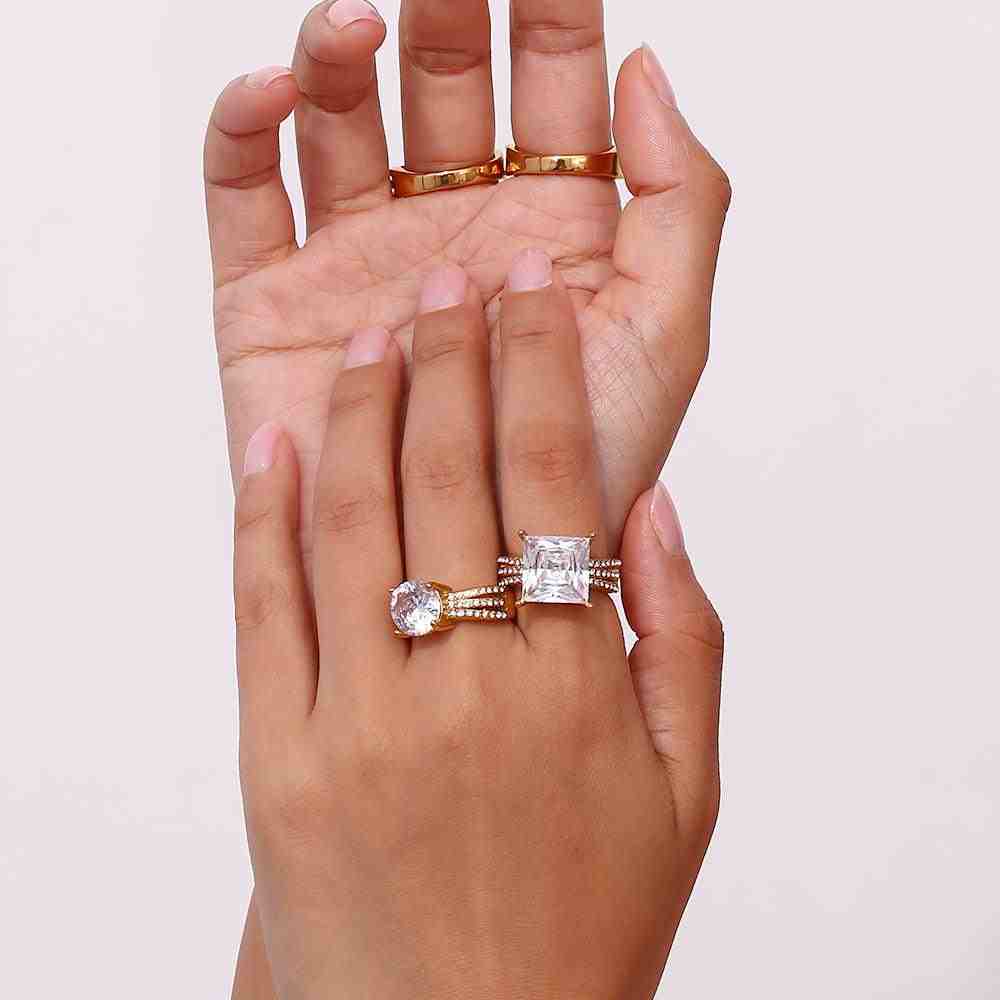 Both hands Wearing 18k gold plated rings including aurora diamond round zircon ring and aura big square zircon ring.