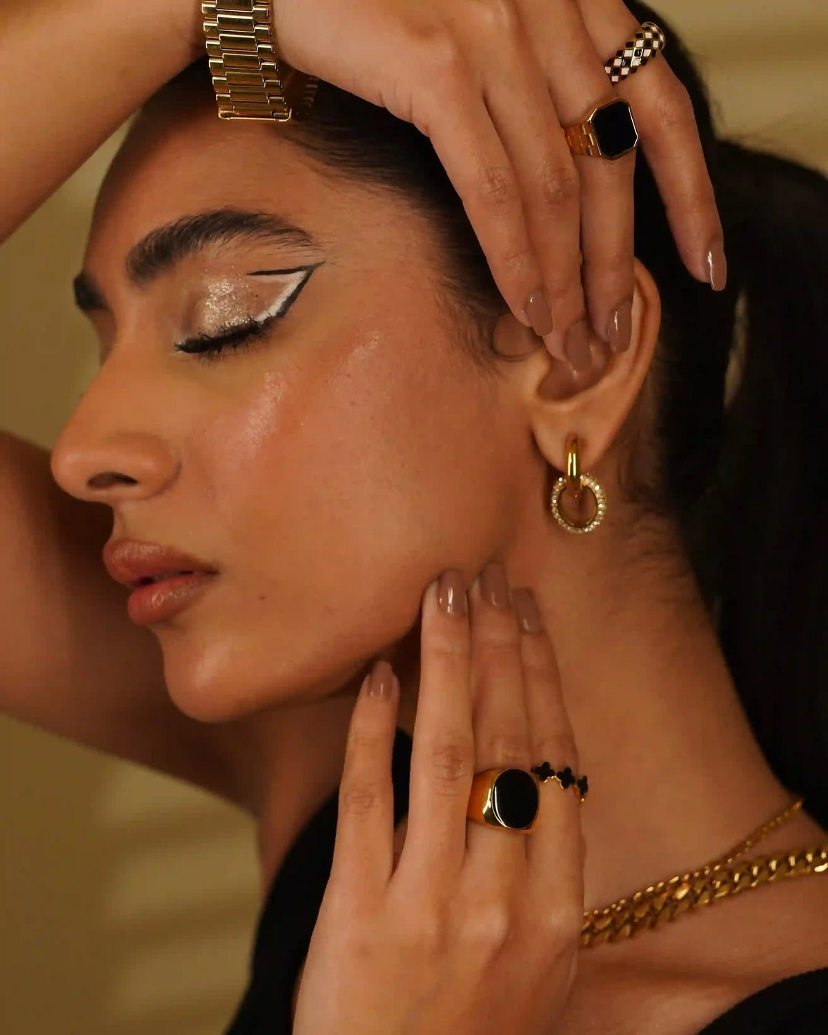 Girl stacked in Gold Plated Earrings, Necklaces, Bracelets, and rings including adjustable Enamel Four-Leaf Clover Motif Black band ring.
