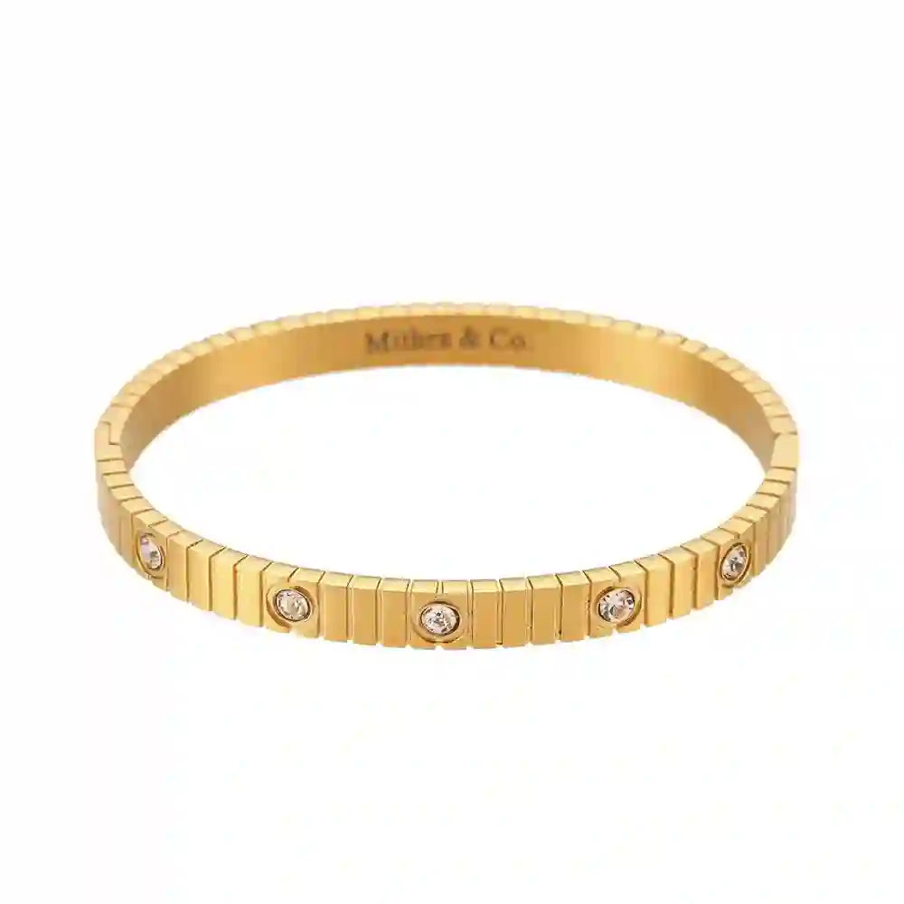 Studio shot of 18k Gold plated Coil Studded Bangle with Ribbed Texture and Bezel-Set CZ Stones. Shop at Mithra and Co.