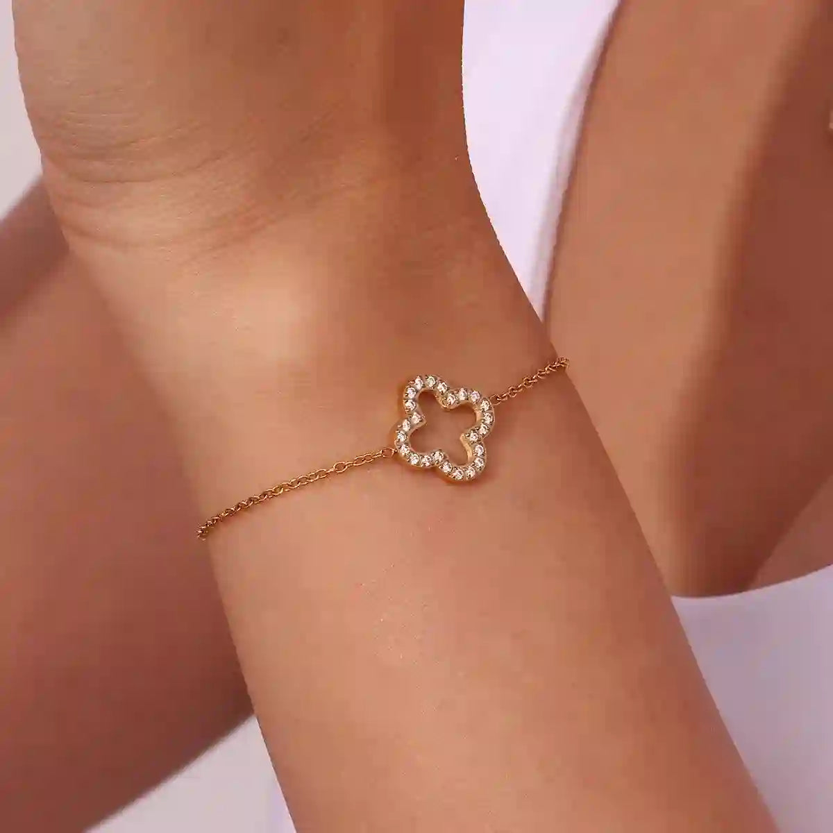 Closeup of a hand wearing Hollow Clover Studded Bracelet. An Open Hollow Silhouette Quatrefoil Design with Pave Zircon Setting.