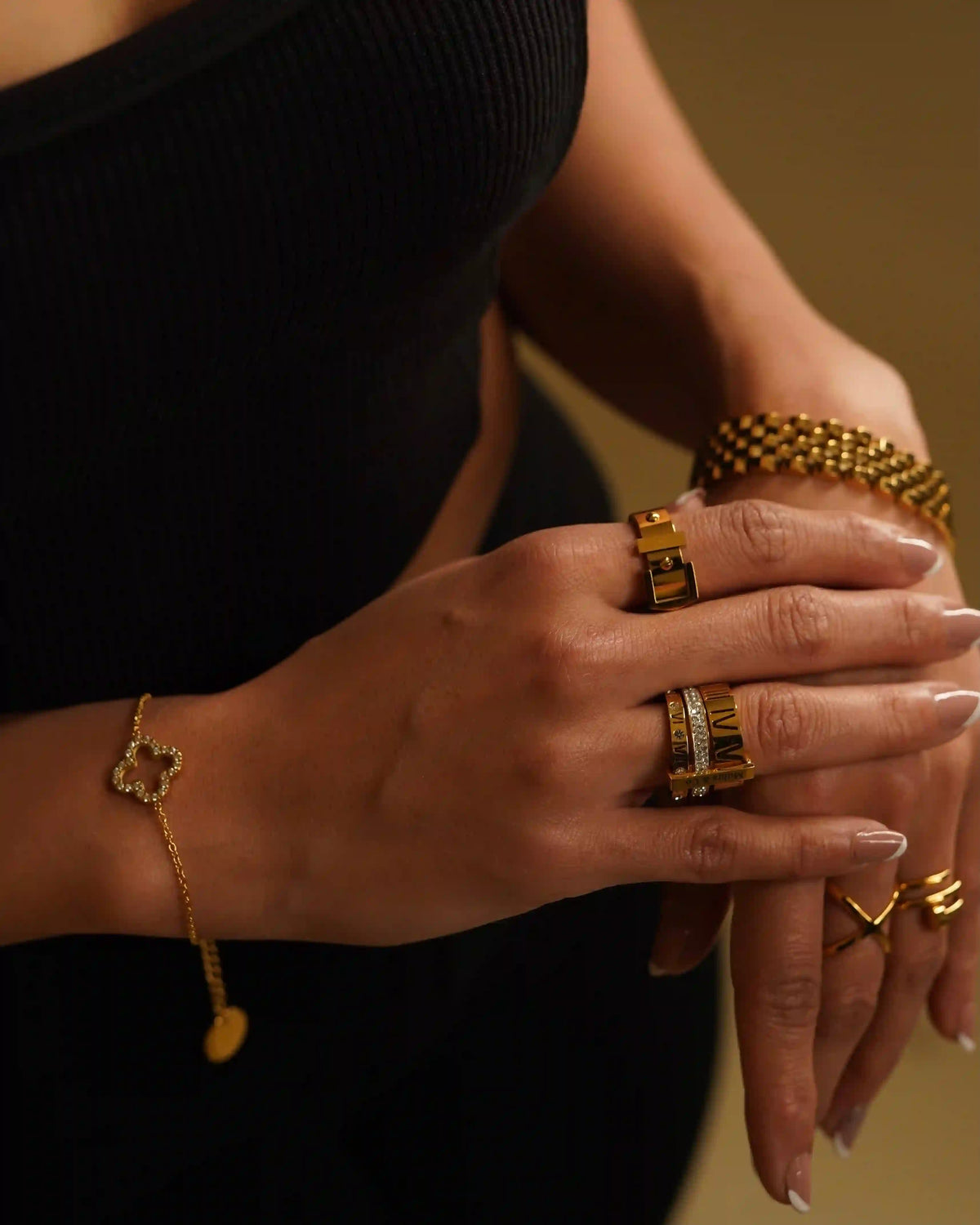 Closeup of boh hands wearing Michael Bold Bracelet with Trilogy stacked ring BUckle up ring and petite Hollow Clover Studded Bracelet layered with Pave Zircons.