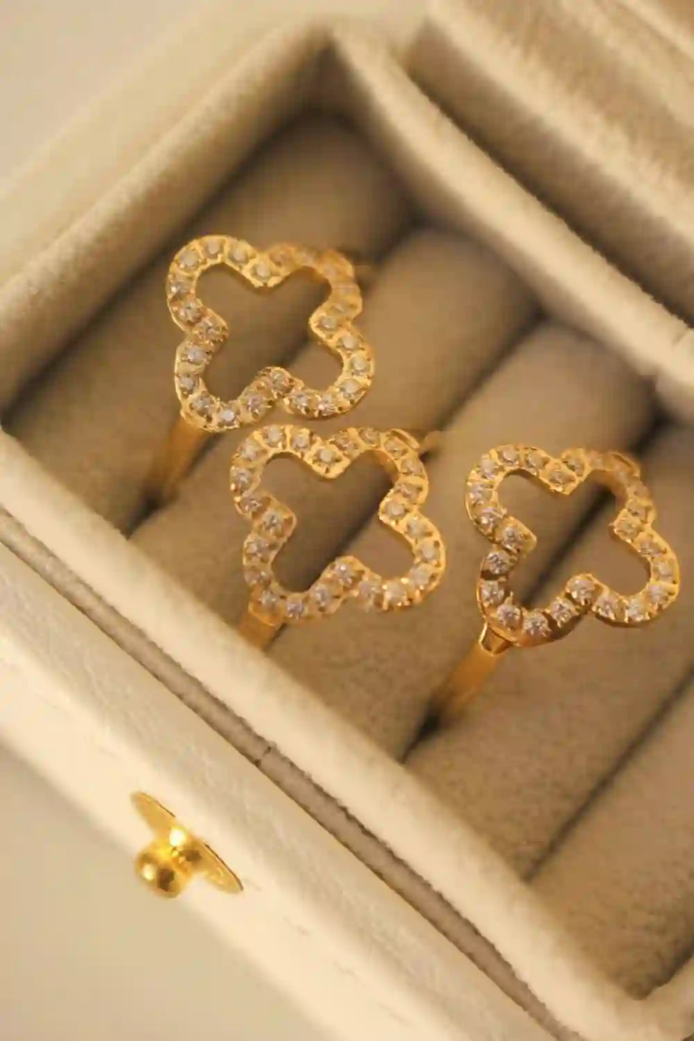 Open drawer displaying 3 hollow clover studded rings with Floral 4 leaf motifs bordered by zircons.
