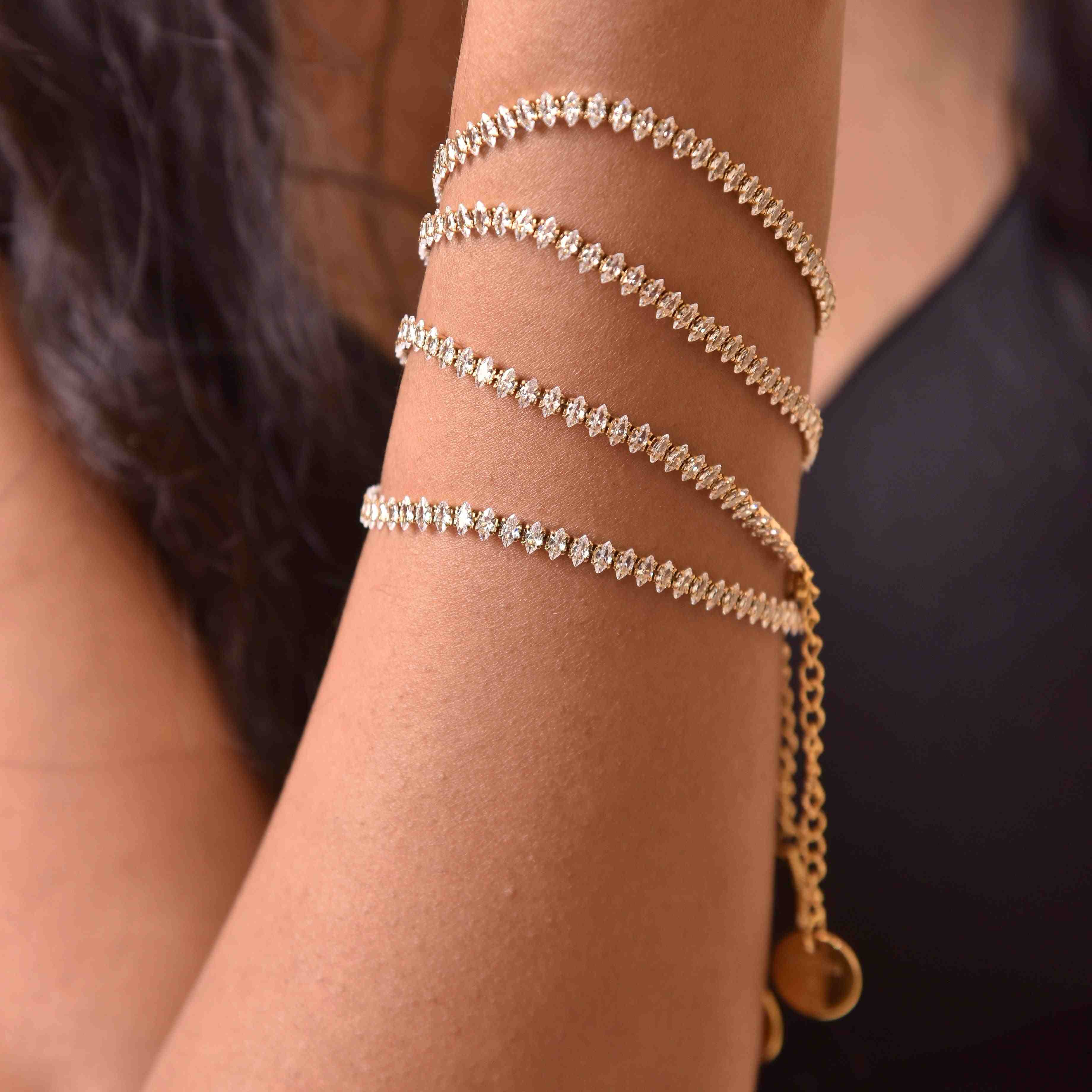 Woman wearing 18k Gold Plated CZ Tennis Bracelet wrapped around wrist, sparkling stones