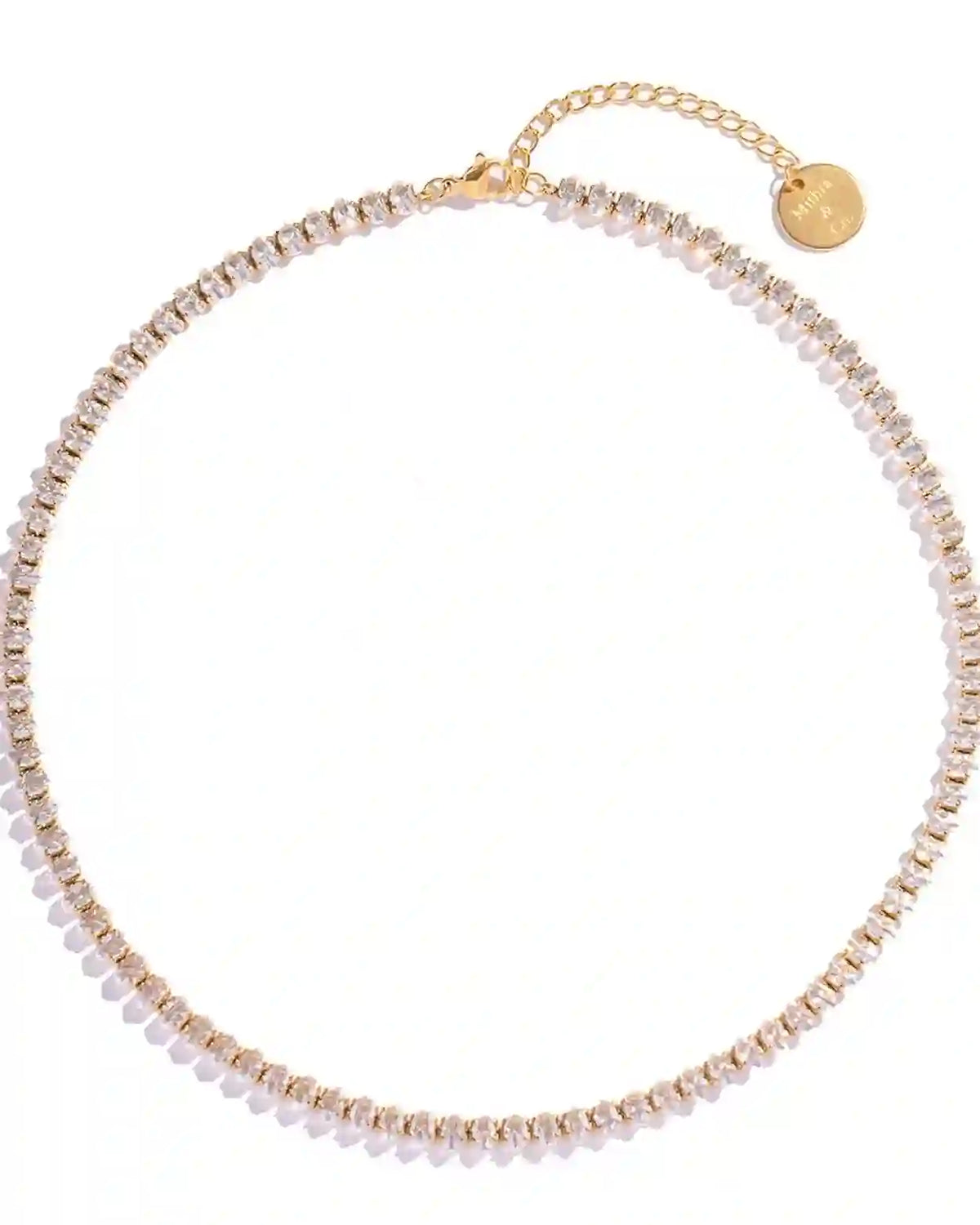 Studio shot of Linea Tennis Necklace with gold plating and bead style cubic zirconia box chain links on a white background