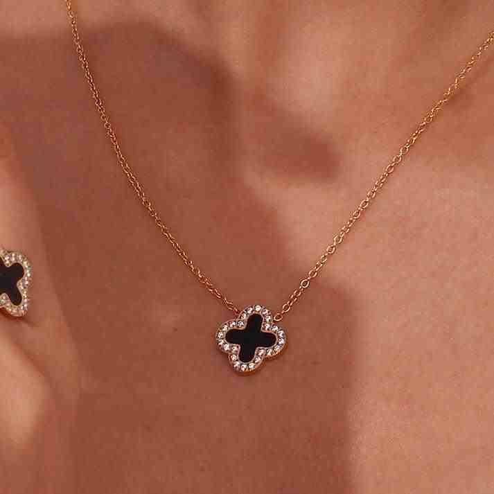 Closeup of 18k Gold plated Black Midnight Clover Necklace. Zircons around and black Onyx-Inlaid 4 Leaf clover stone in center. Shop at Mithra and Co.