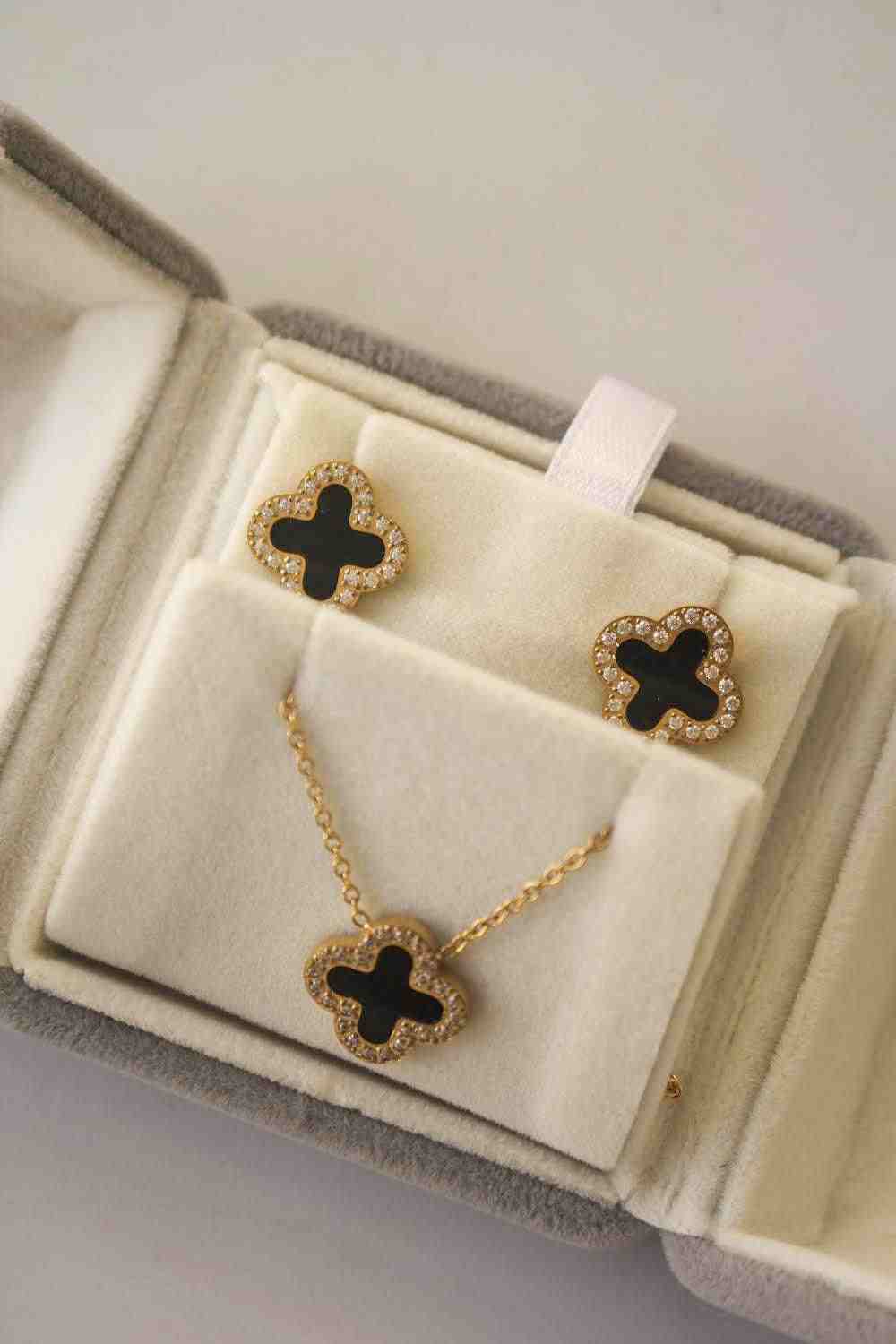 Closeup of Midnight Clover Necklace 3 Motifs. Featuring Zircons Bordering the Onyx-Inlaid 4 leaf Clover Silhouette.