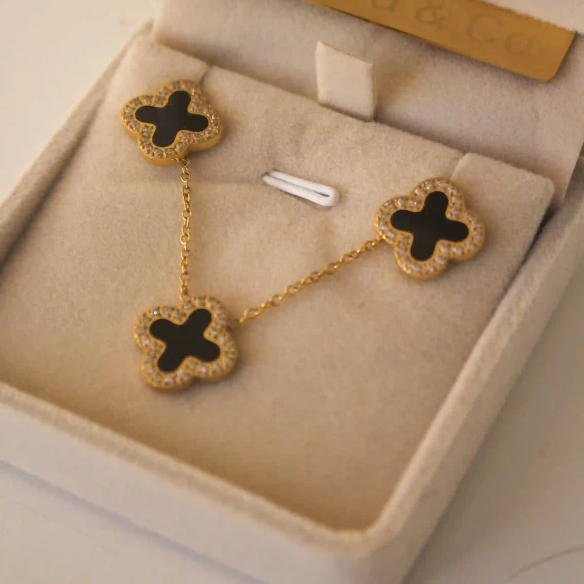 Closeup of 3 Motifs for Midnight Clover Necklace featuring Zircon engraving around the Black Onyx Inlaid 4 leaf clover silhouette.