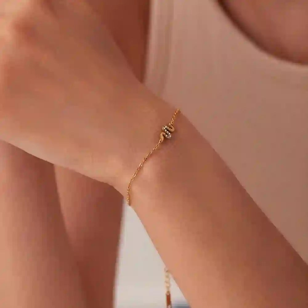 GIrl wearing Petite Snake bracelet. 18k Gold Plated Danity Chain with Zircon accented Pavé Slither Motif.