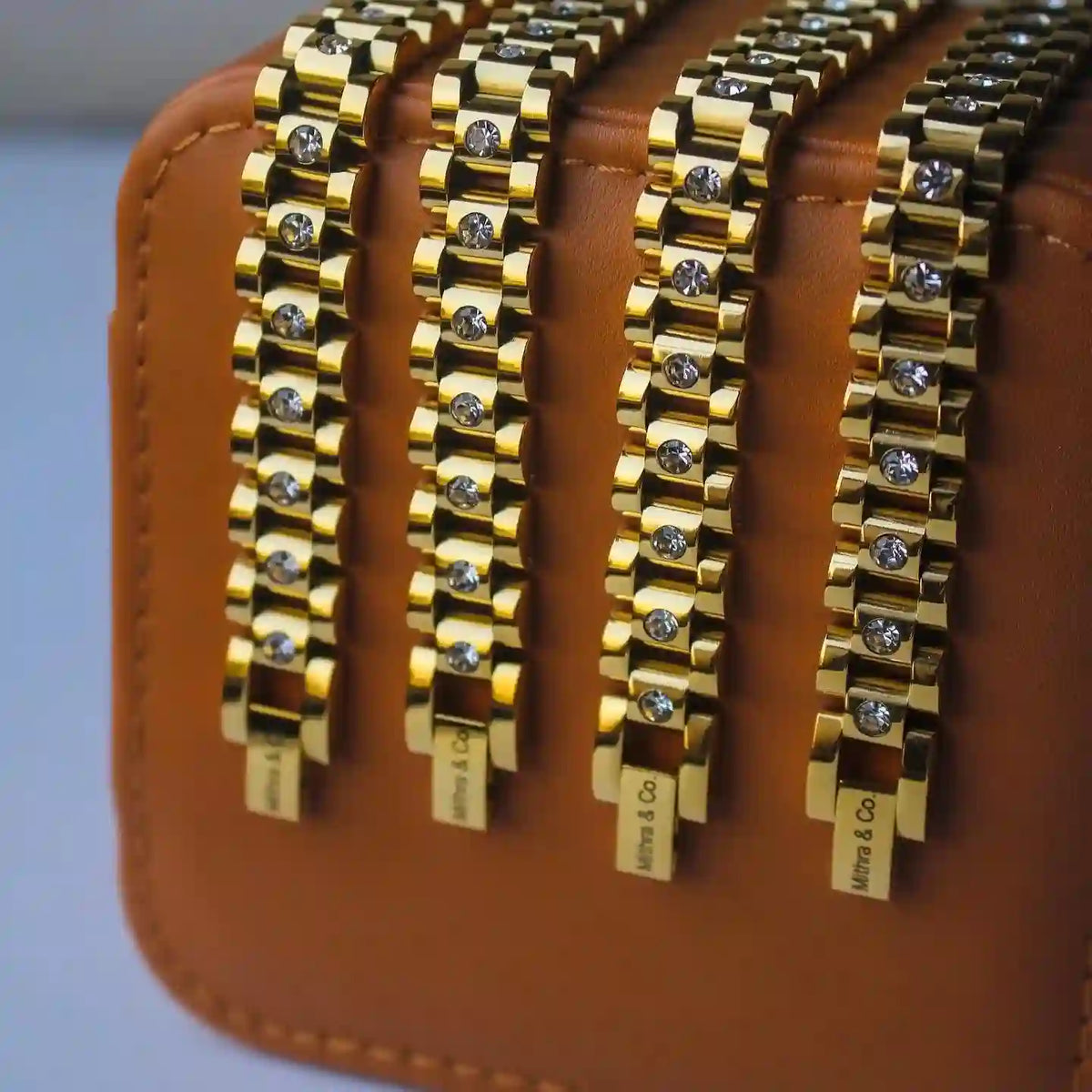 Closeup of 4 Micro Zircon studded michael bold bracelets put on a light brown jewelry box for showcase.