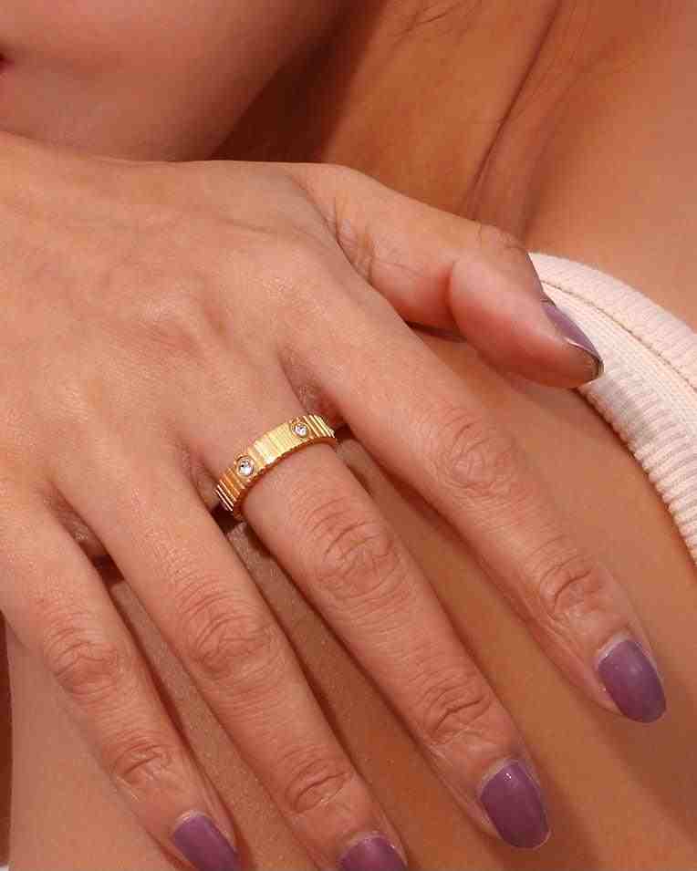 Closeup of a girl's hand wearing Waterproof 18k Gold plated Coil Studded Ring and indigo nailpaint pose hand on shoulder.