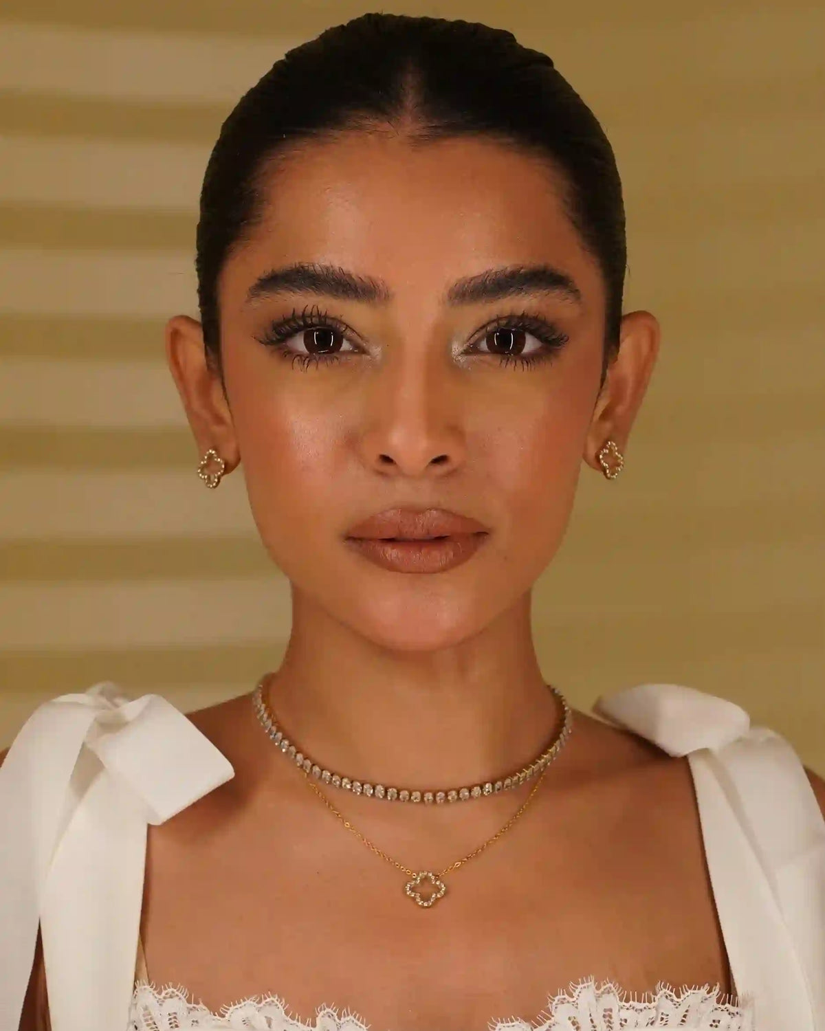 Woman wearing Linea Necklace with Hollow Clover Studded Studs and Necklace featuring Open-Work Zircon Clover Architecture.