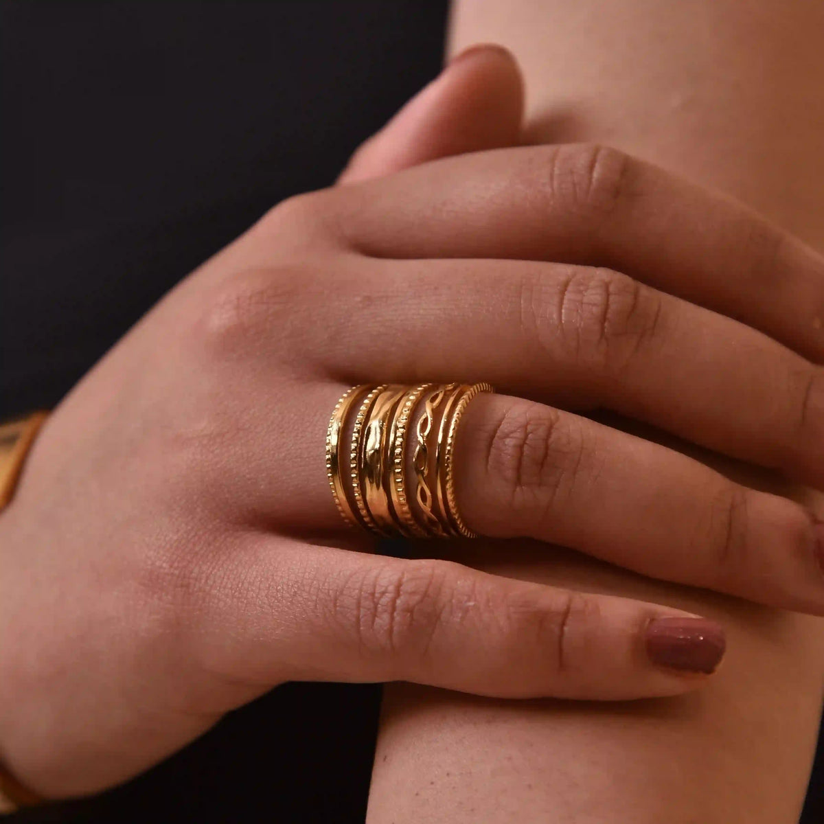 closeup of hand wearing Salento Ring in ring finger. Adjustable gold band ring with textured and patterned designs.